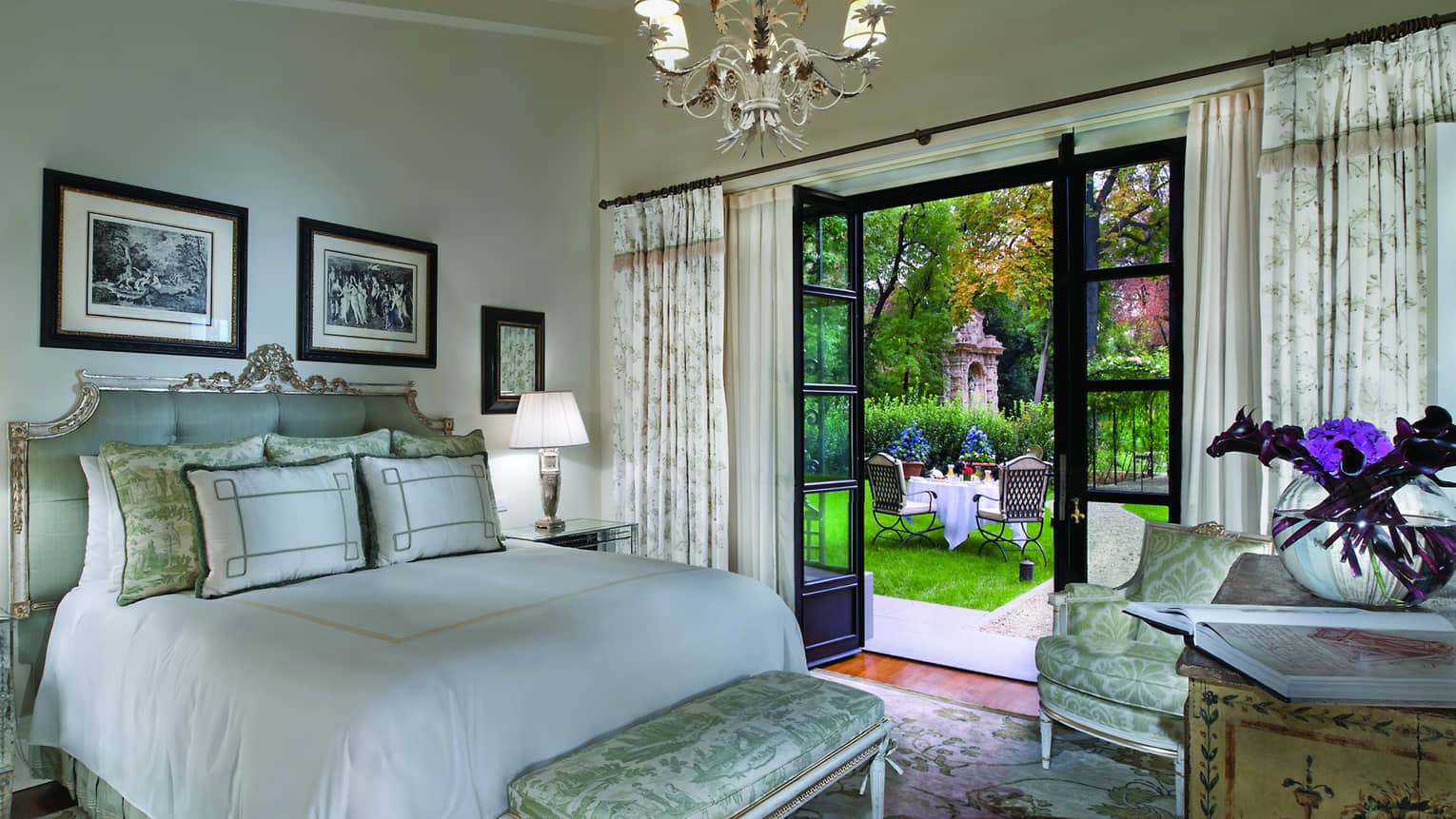 Garden Suite bed with tufted blue headboard, silk bench, open doors to garden patio