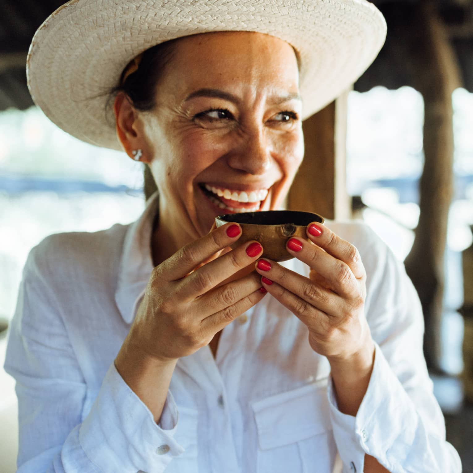 Person wearing a hat and holding a wooden bowl.