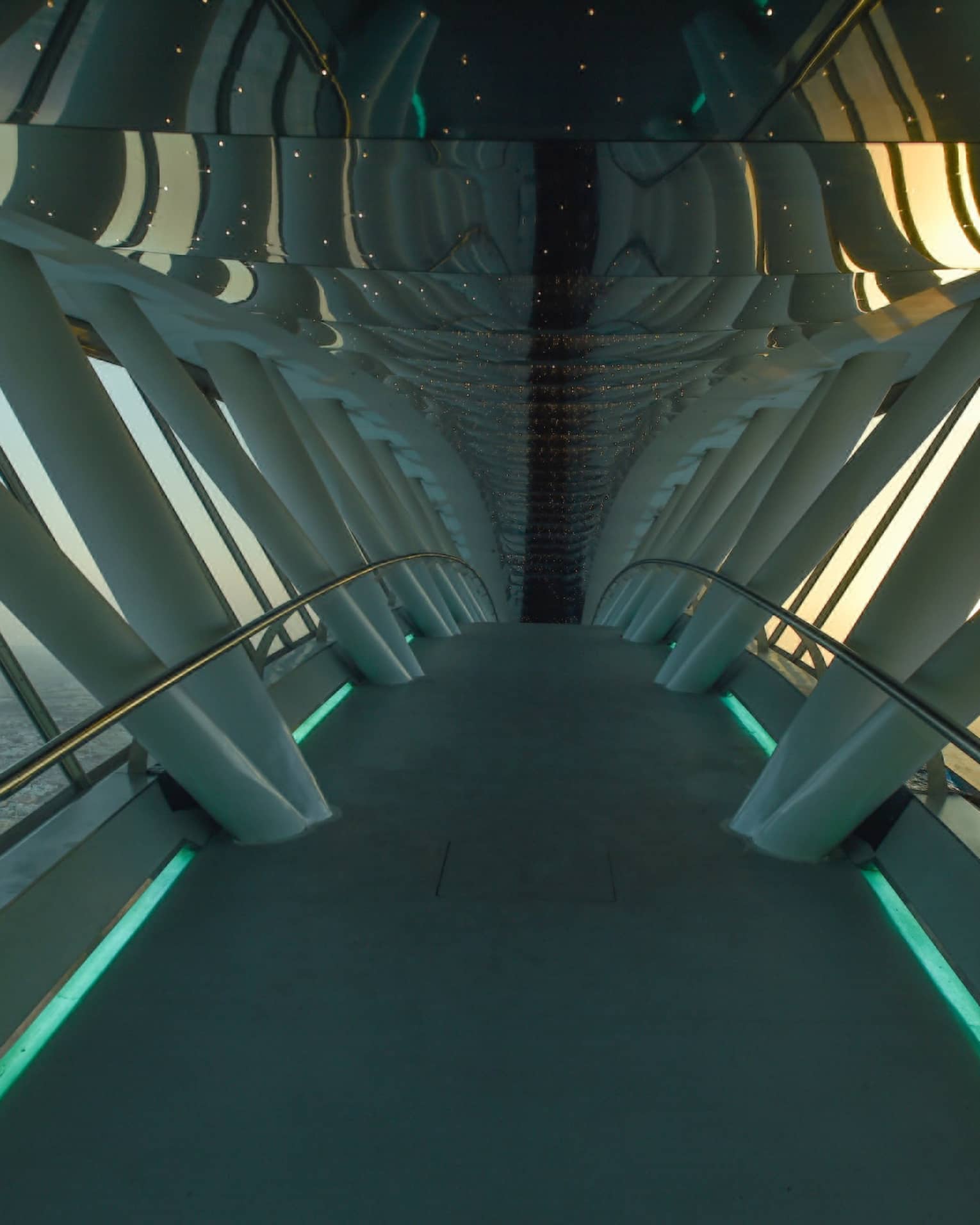 Looking down through white Sky Bridge, city far below