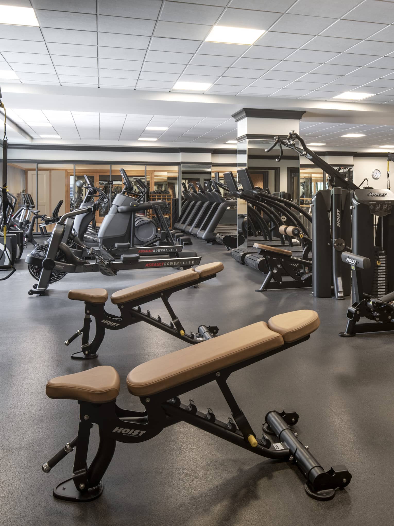 Room with rows of fitness equipment and weights.