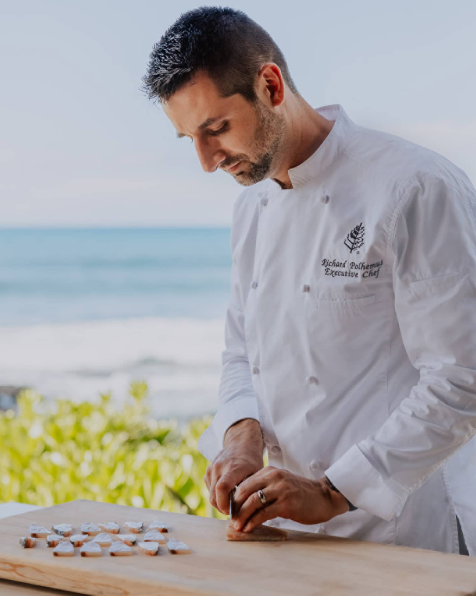 Chef slicing fish by the beach