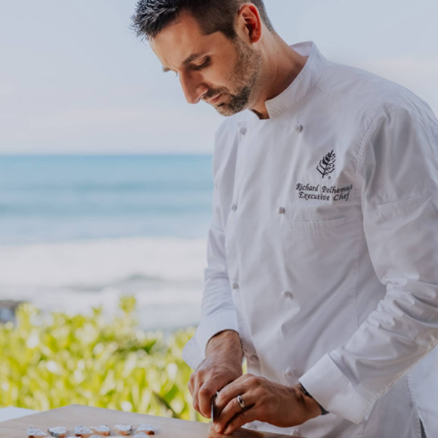 Chef slicing fish by the beach