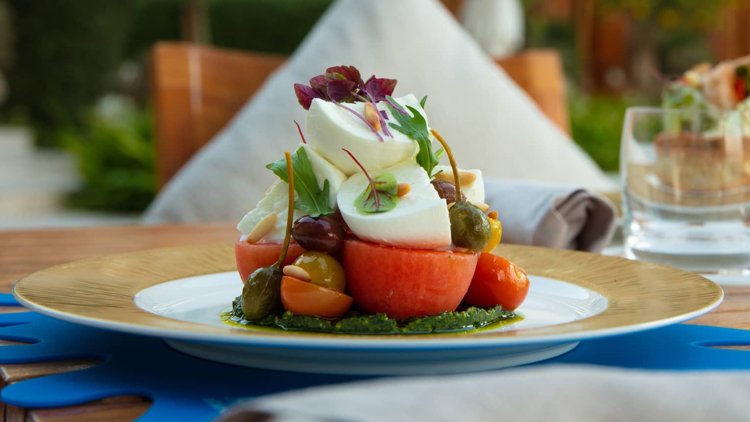 A tomato dish with mozzarella and other colourful vegetables. 