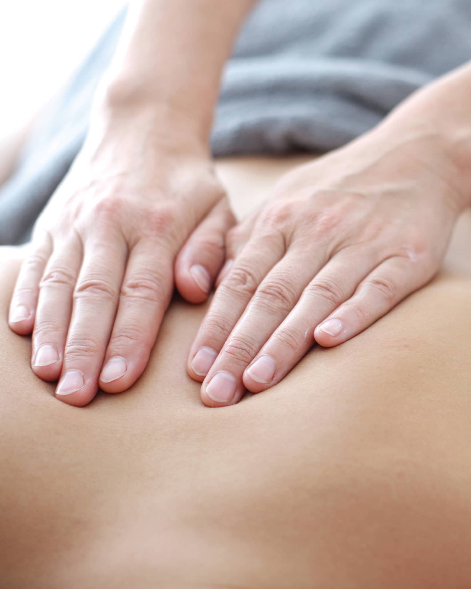 Hands massaging bare shoulders, back