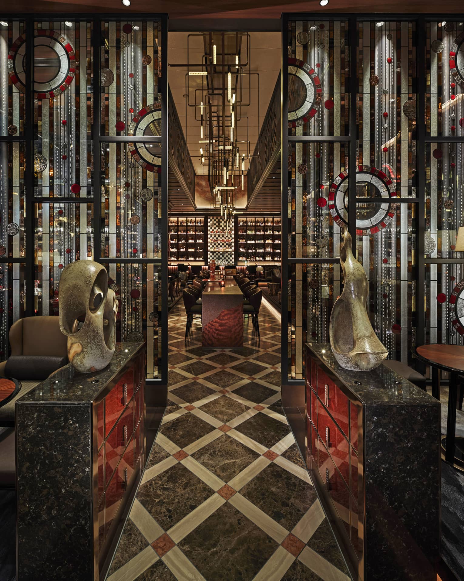 Entryway to VIRTU with sculptures, low lighting, red and black accents
