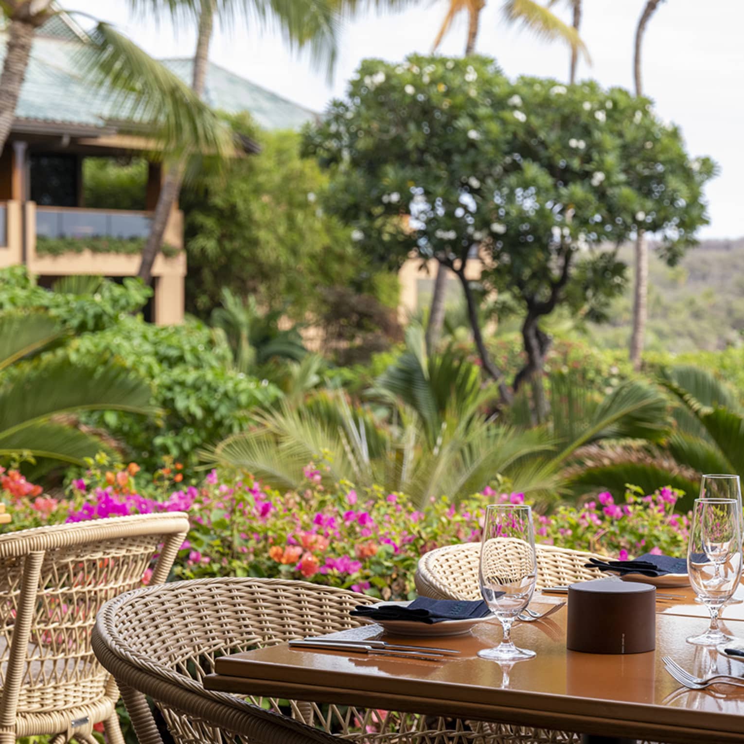 Table set beside lush garden overlooking the ocean