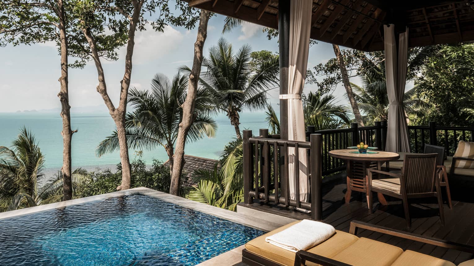 Premier One-Bedroom Pool Villa patio with chairs, table by plunge swimming pool with ocean views
