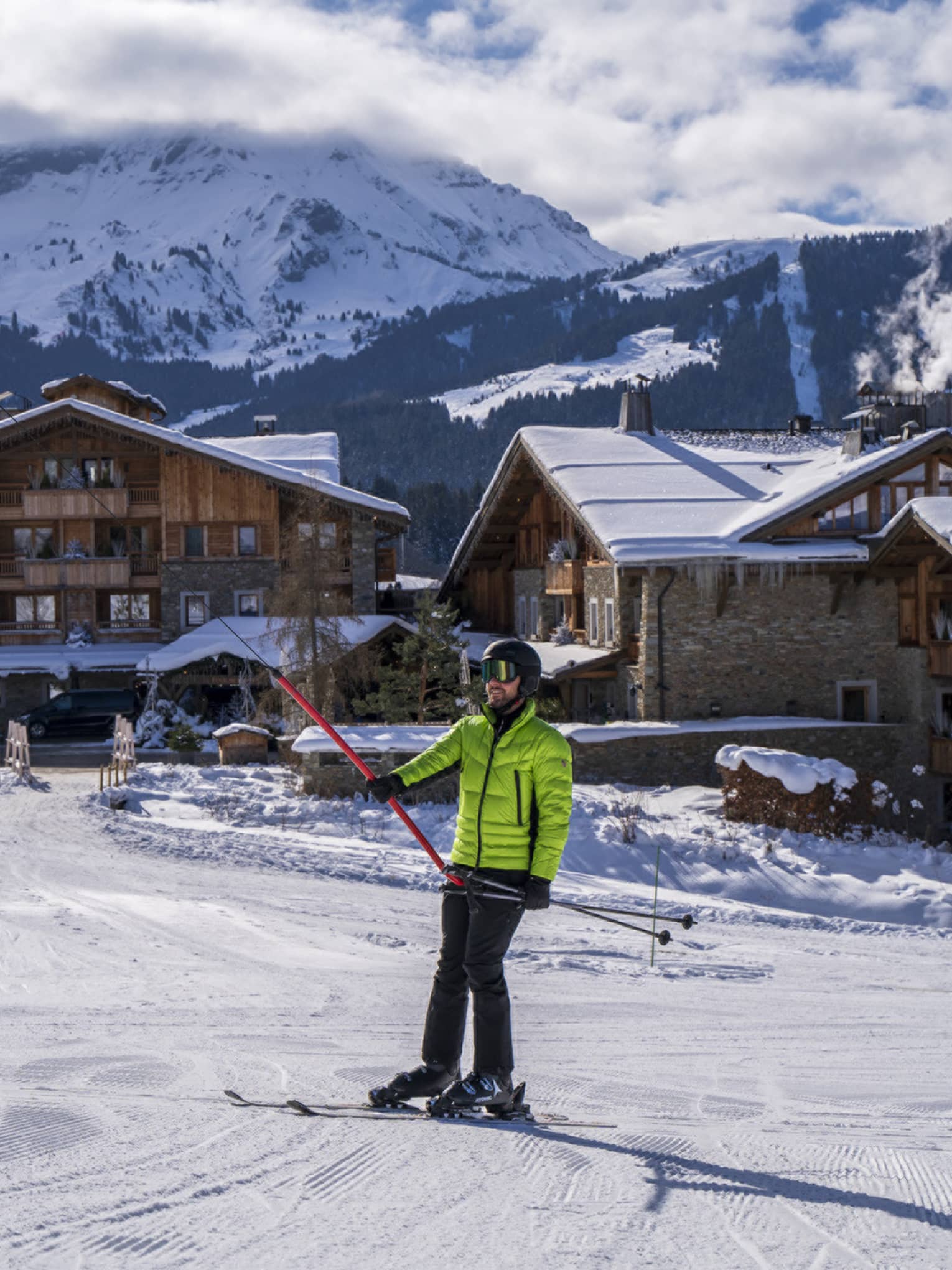 A person in a bright green ski jacket on snow.