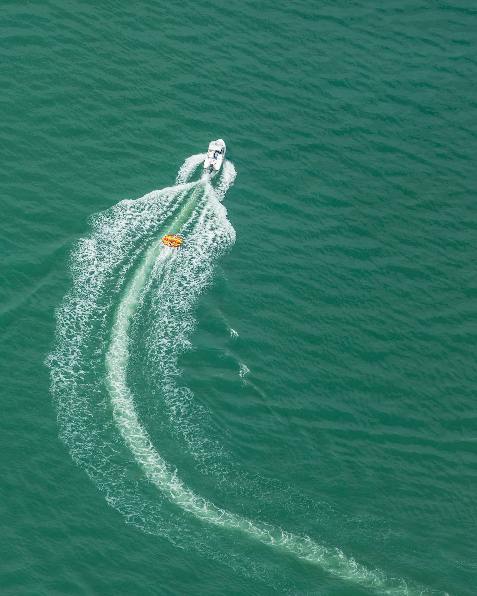 Aerial view of a boat moving through the ocean.