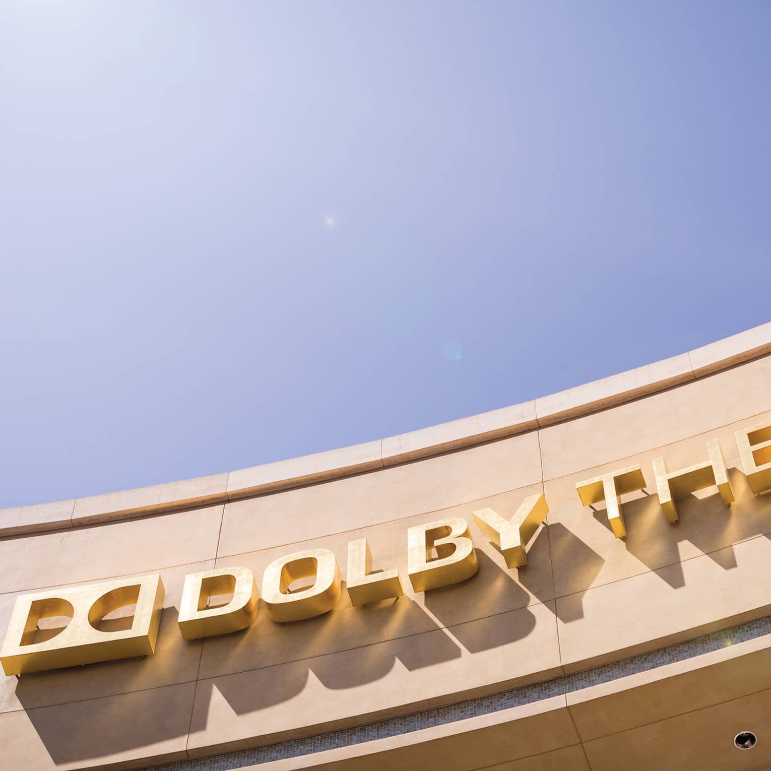 Curved Dolby Theatre sign against sunny blue sky