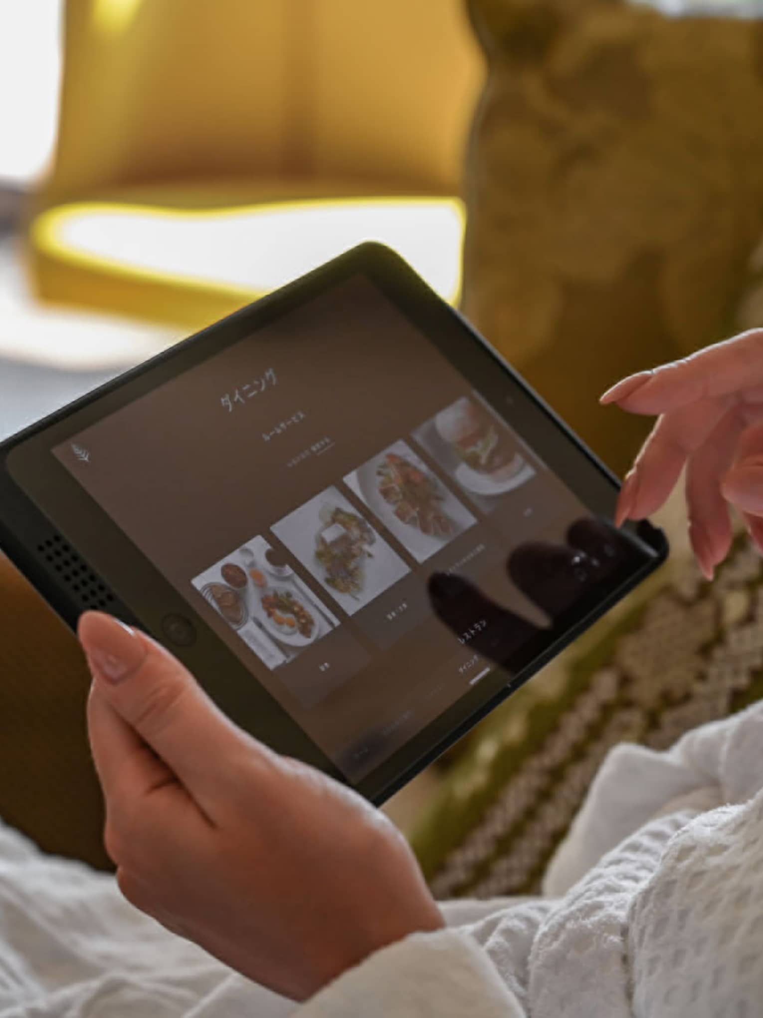 Guest using an in-room tablet to browse dining options