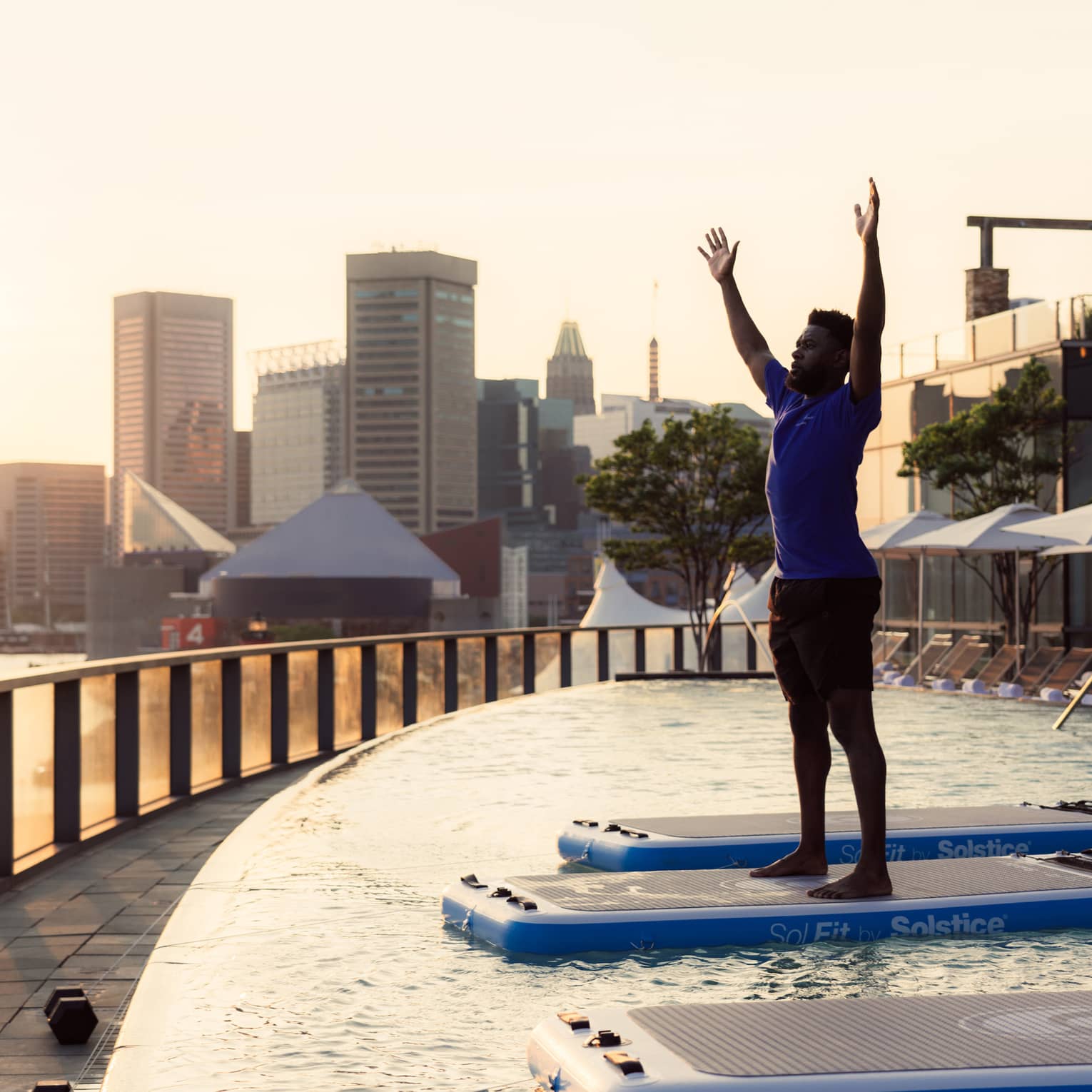 Guest standing in a pool doing pool yoga.
