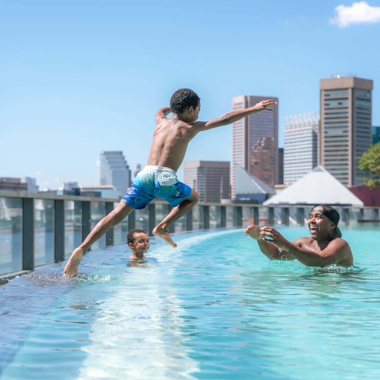Child jumps into pool as parent waits in the water with open arms