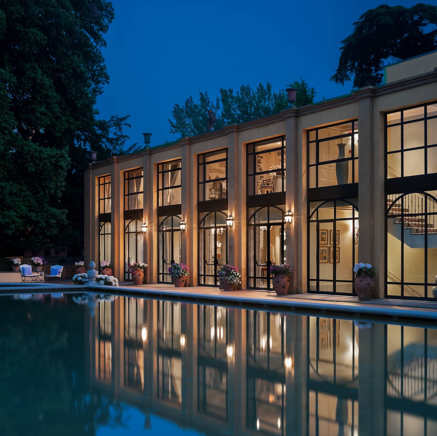Four Seasons Hotel Florence two-level exterior with large picture windows overlooking pool at night