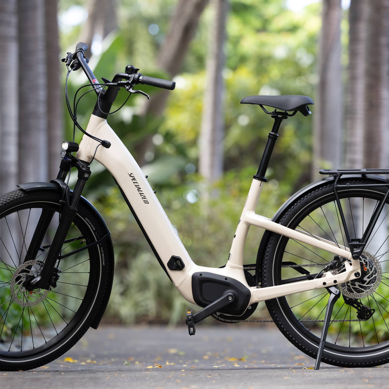 A stationary e-bike on a sidewalk with trees in the background.