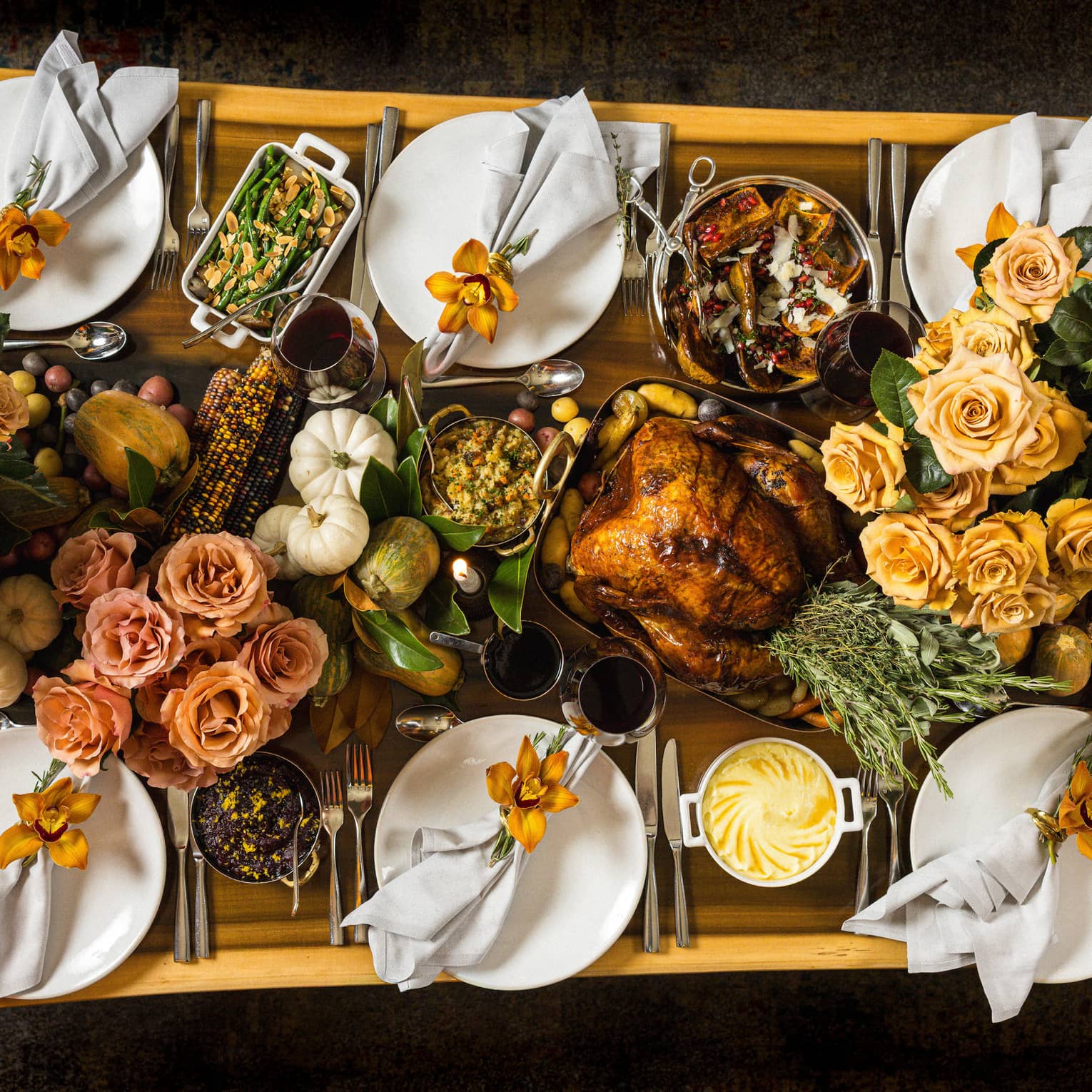 Overhead view of rectangular live-edge wooden table filled with a holiday feast