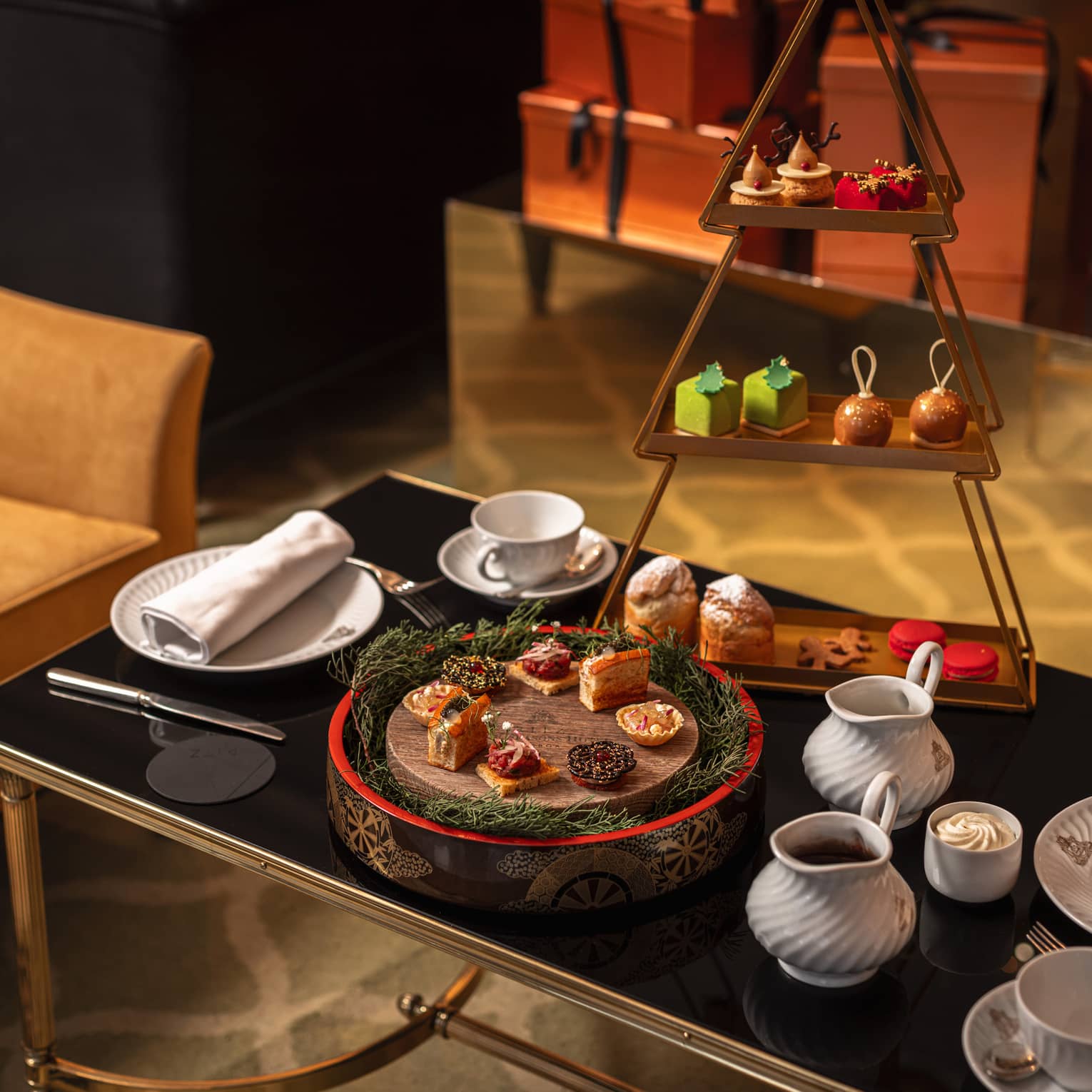 Festive afternoon tea setup on black glass coffee table