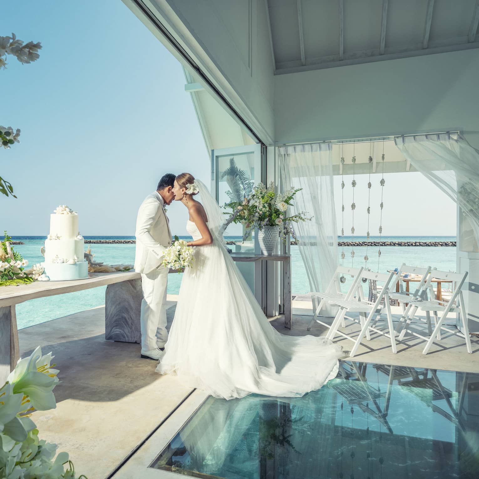 Bride and groom embrace in overwater wedding bungalow