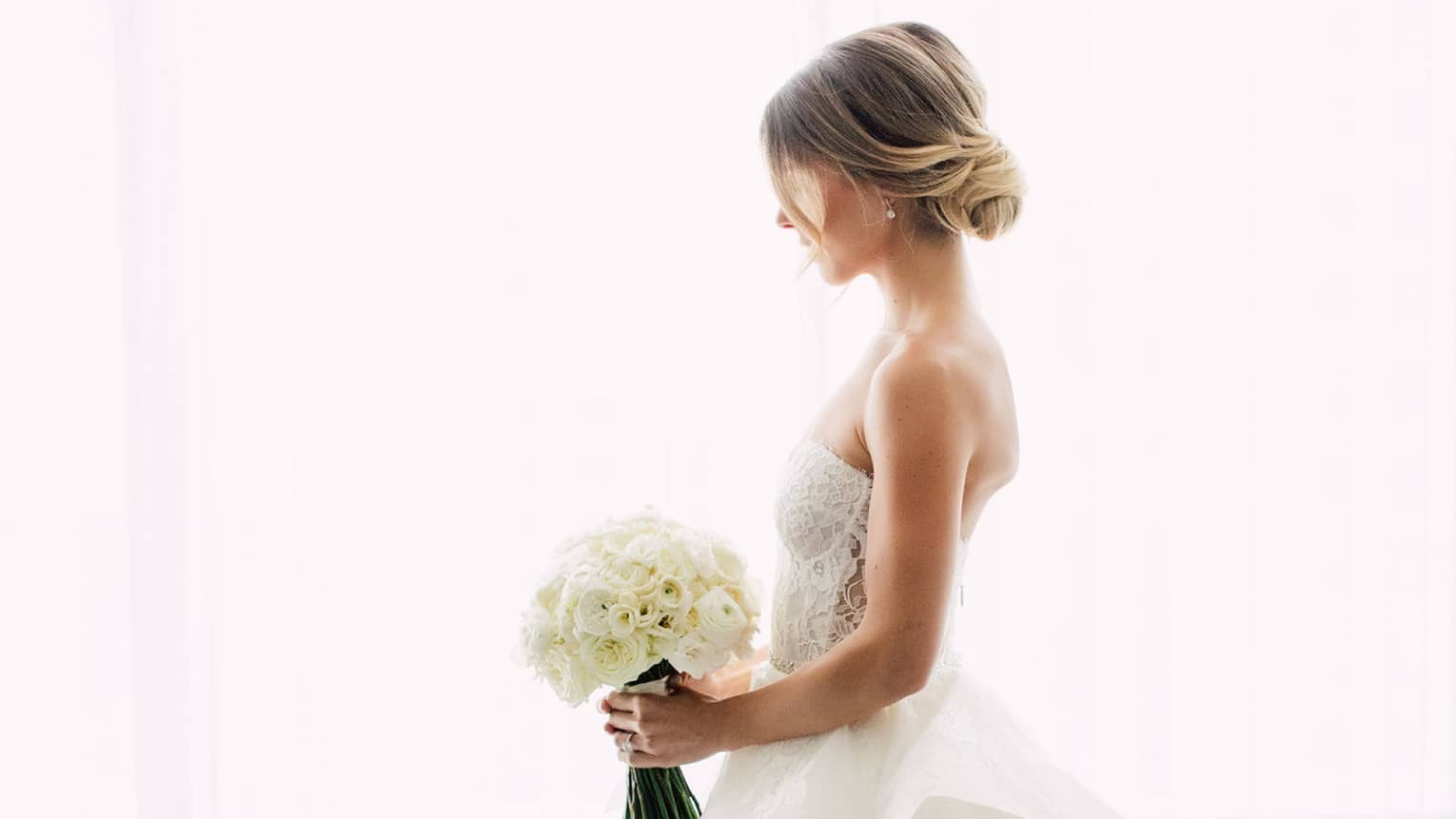 bride on wedding day with bouquet of flowers in luxury hotel