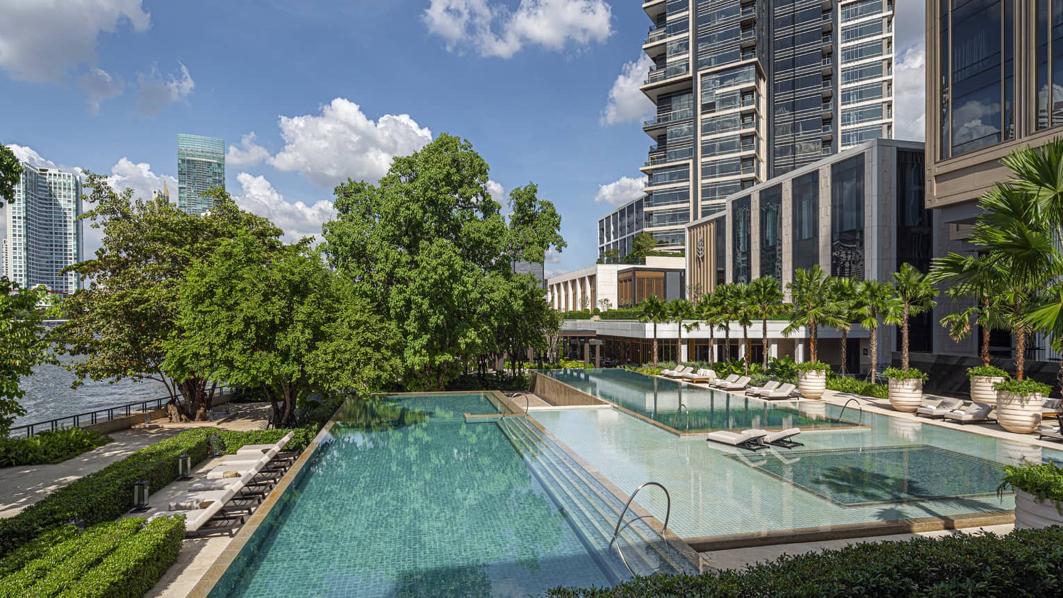 Rectangular hotel pools, staggered, with trees, overlooking Chao Phraya River