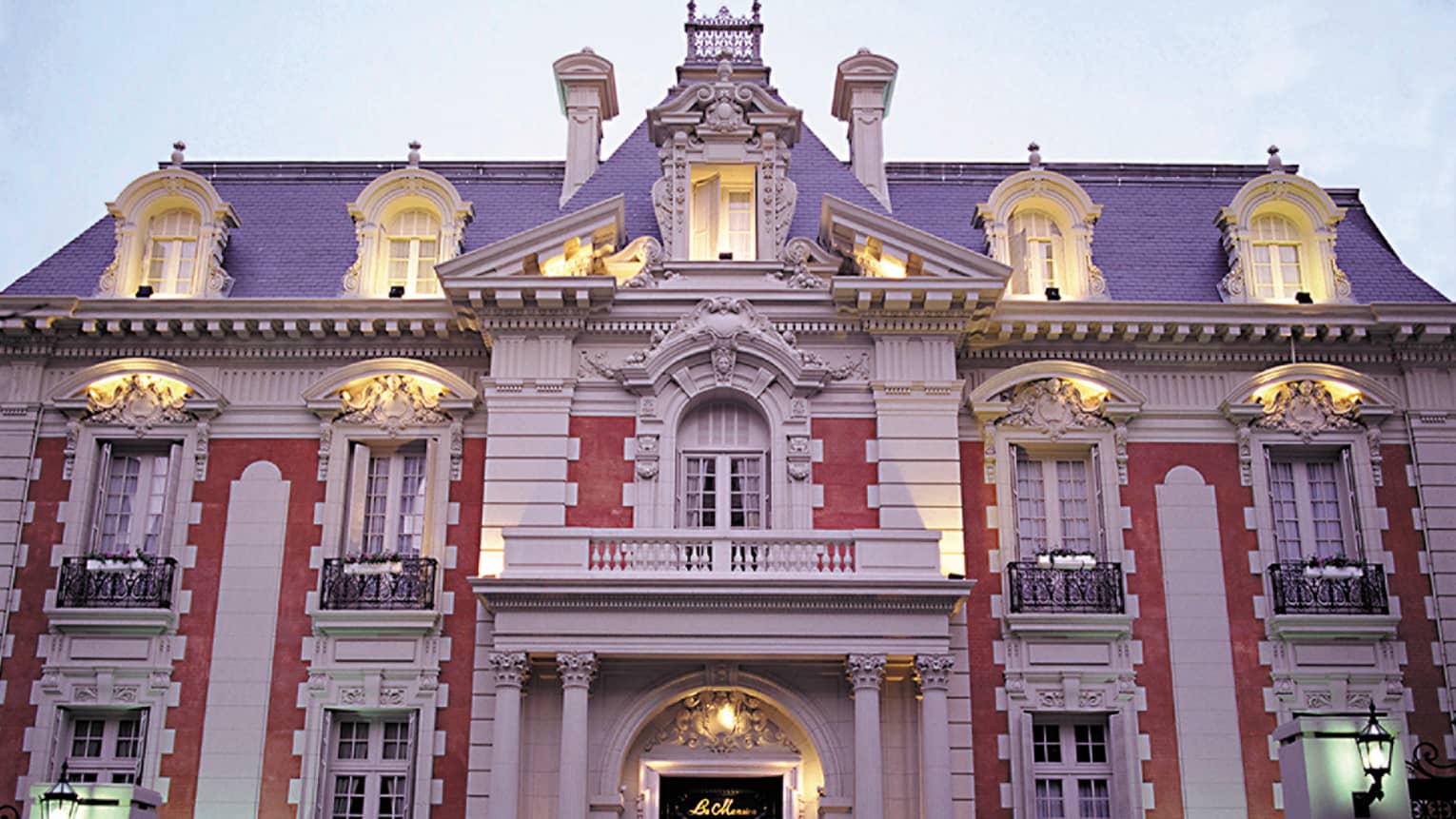 Four Seasons Buenos Aires hotel La Mansión historic exterior with lights at dusk, black fence in front