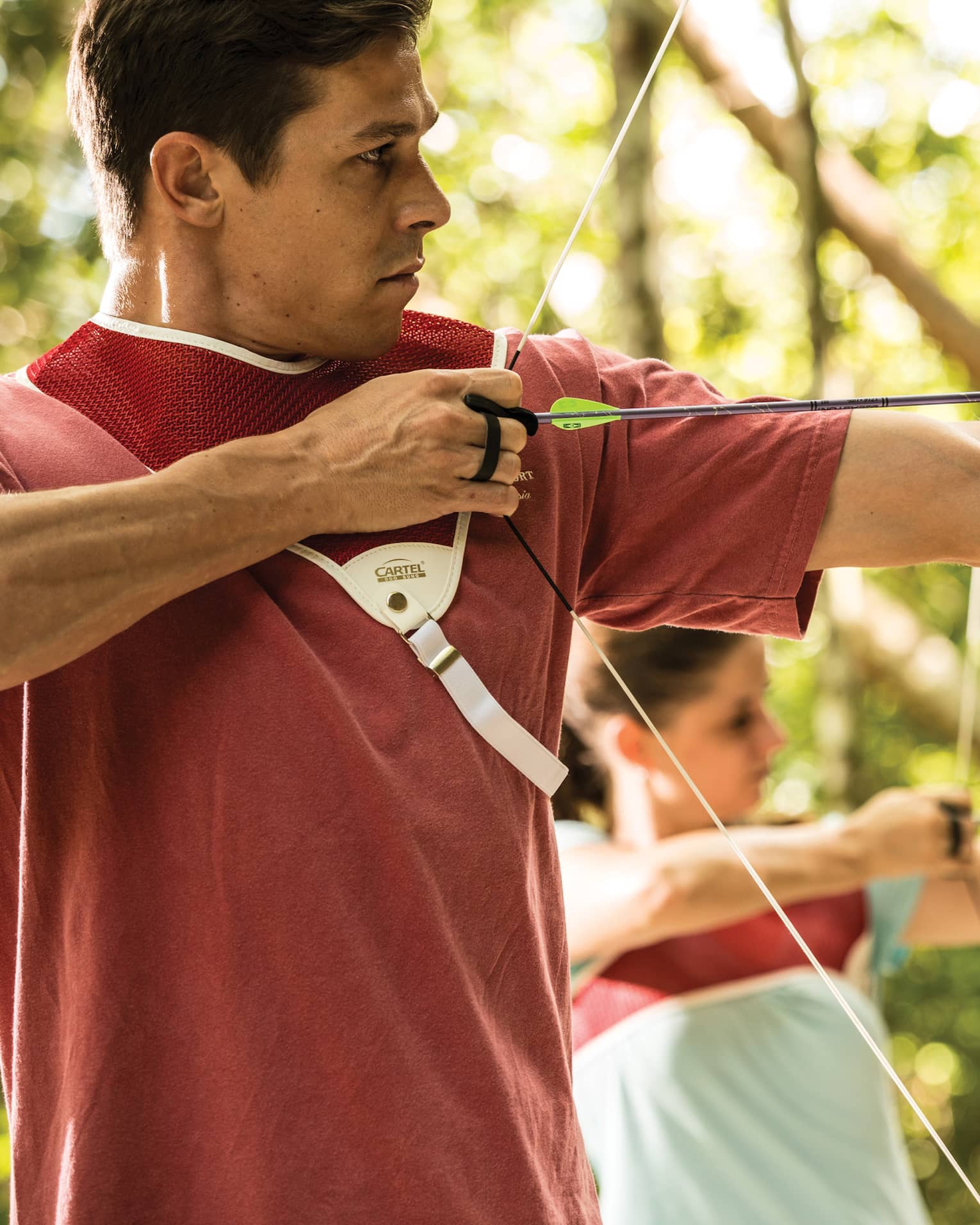 Man and woman hold bow and arrow, prepares to shoot
