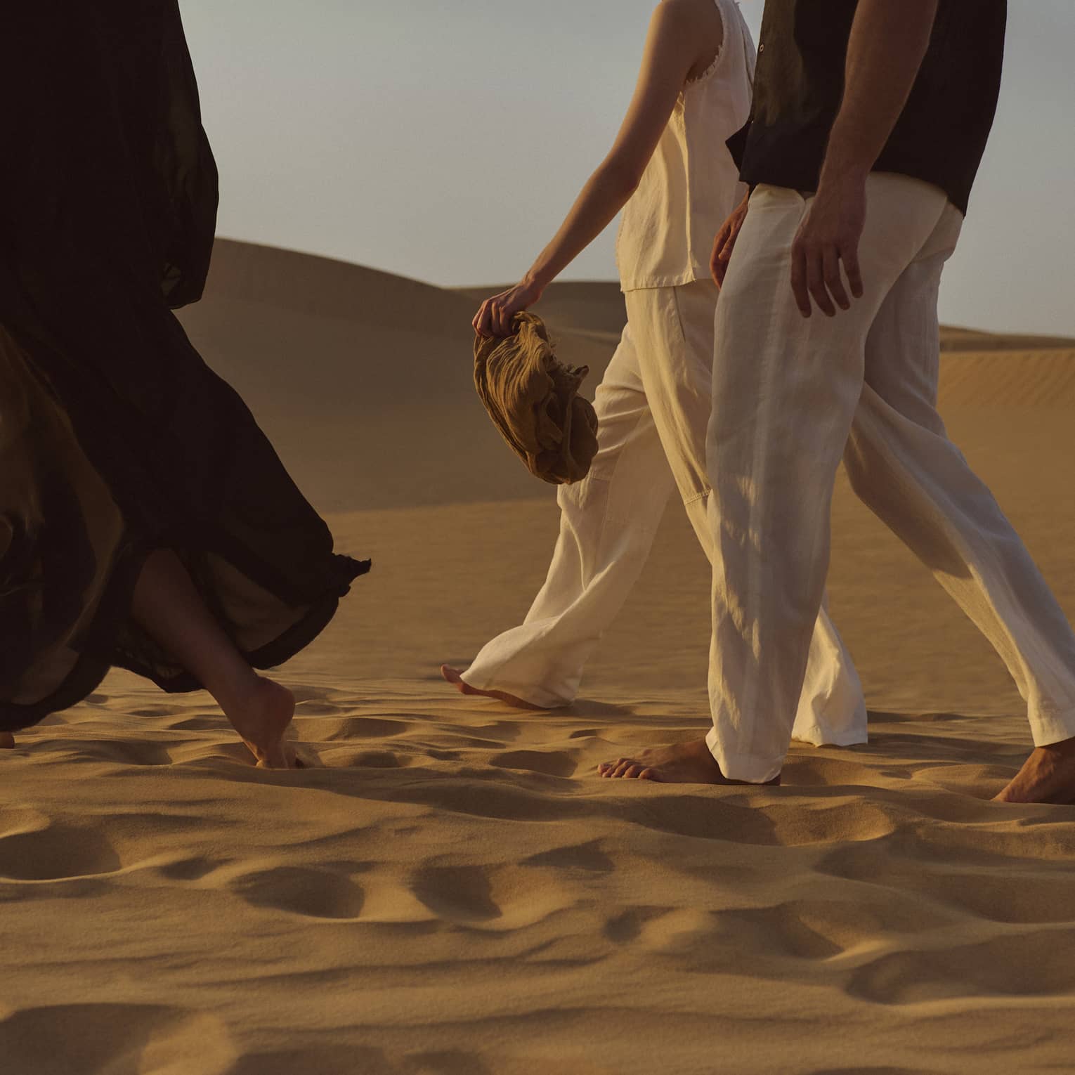 Three people walking in the dessert