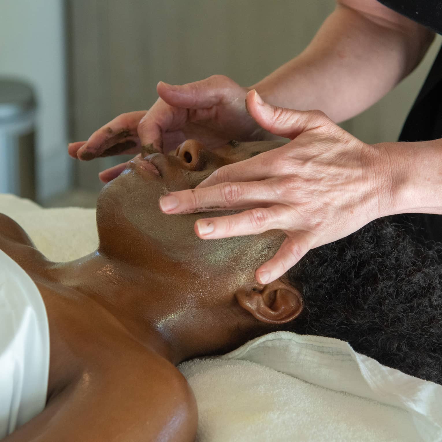 A woman receiving a facial massage.