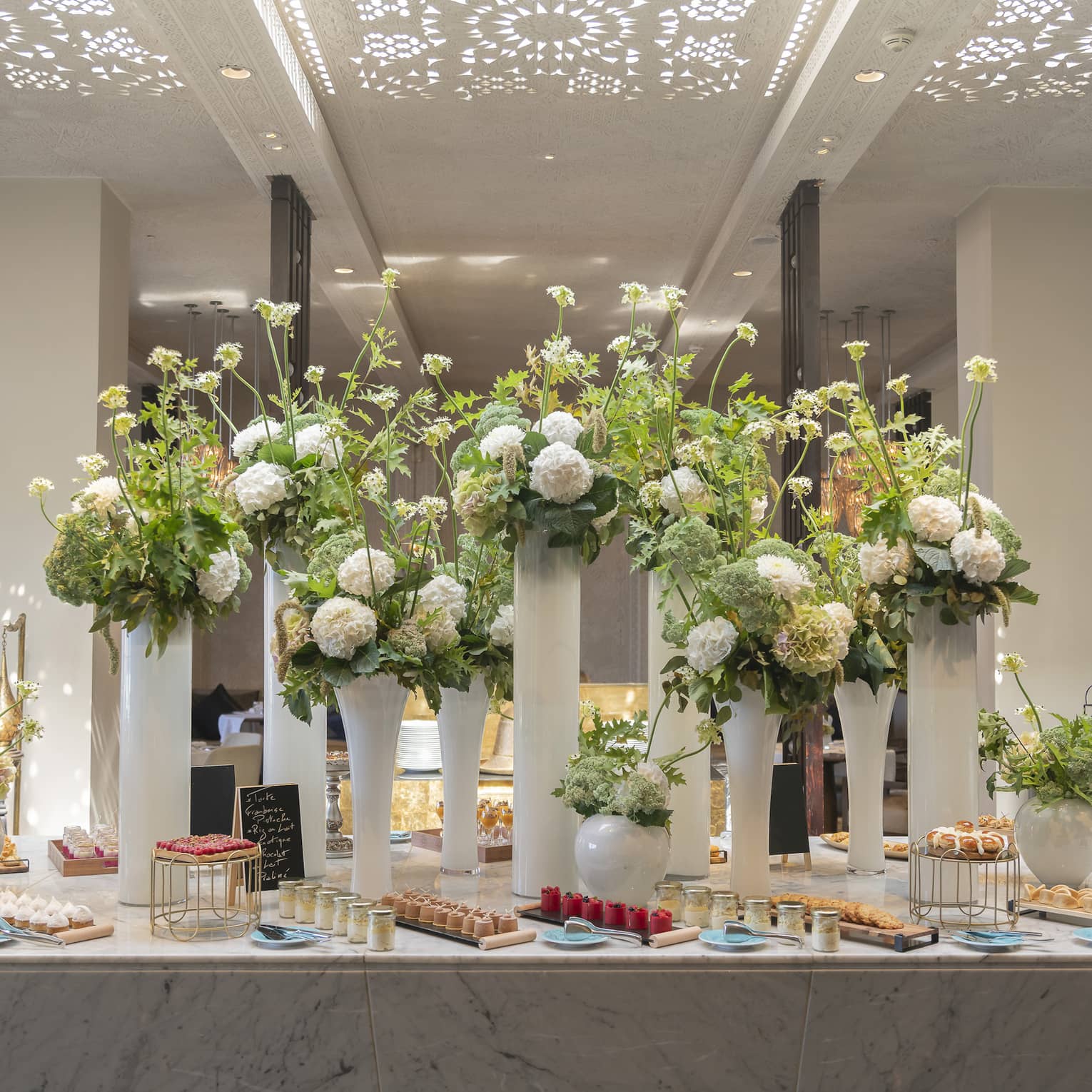 Elaborate buffet at hotel, with large floral arrangements on a table