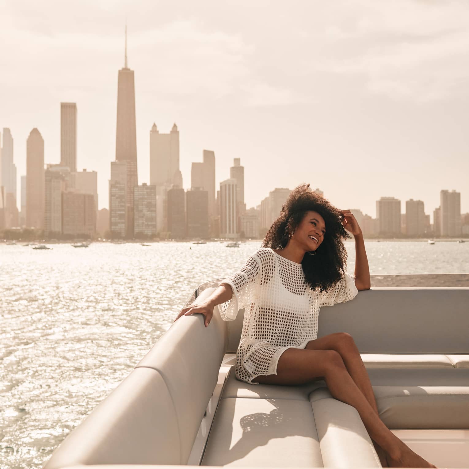Guest wearing a swimsuit on a boat with the city in the background.