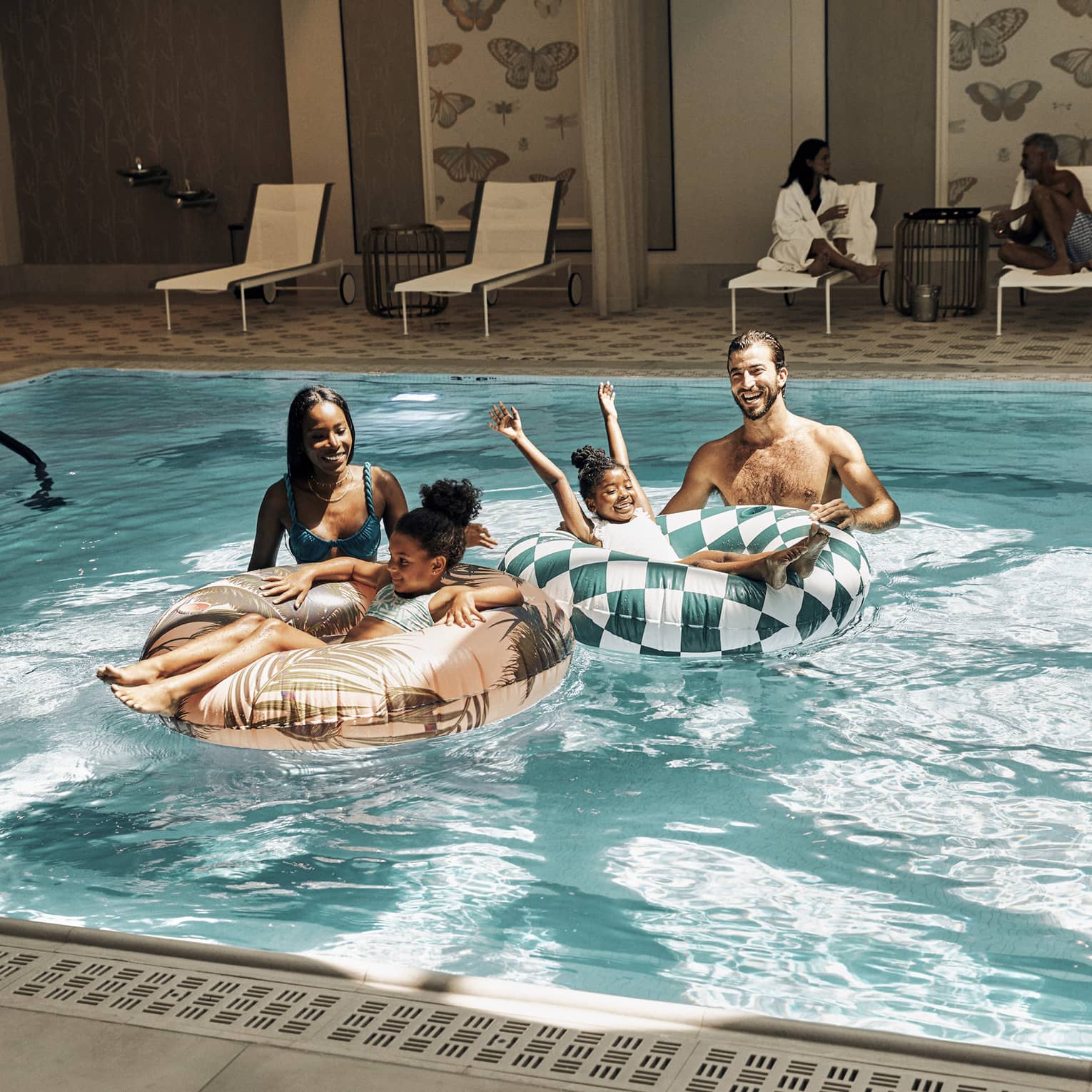 A family in a pool with round tubes.