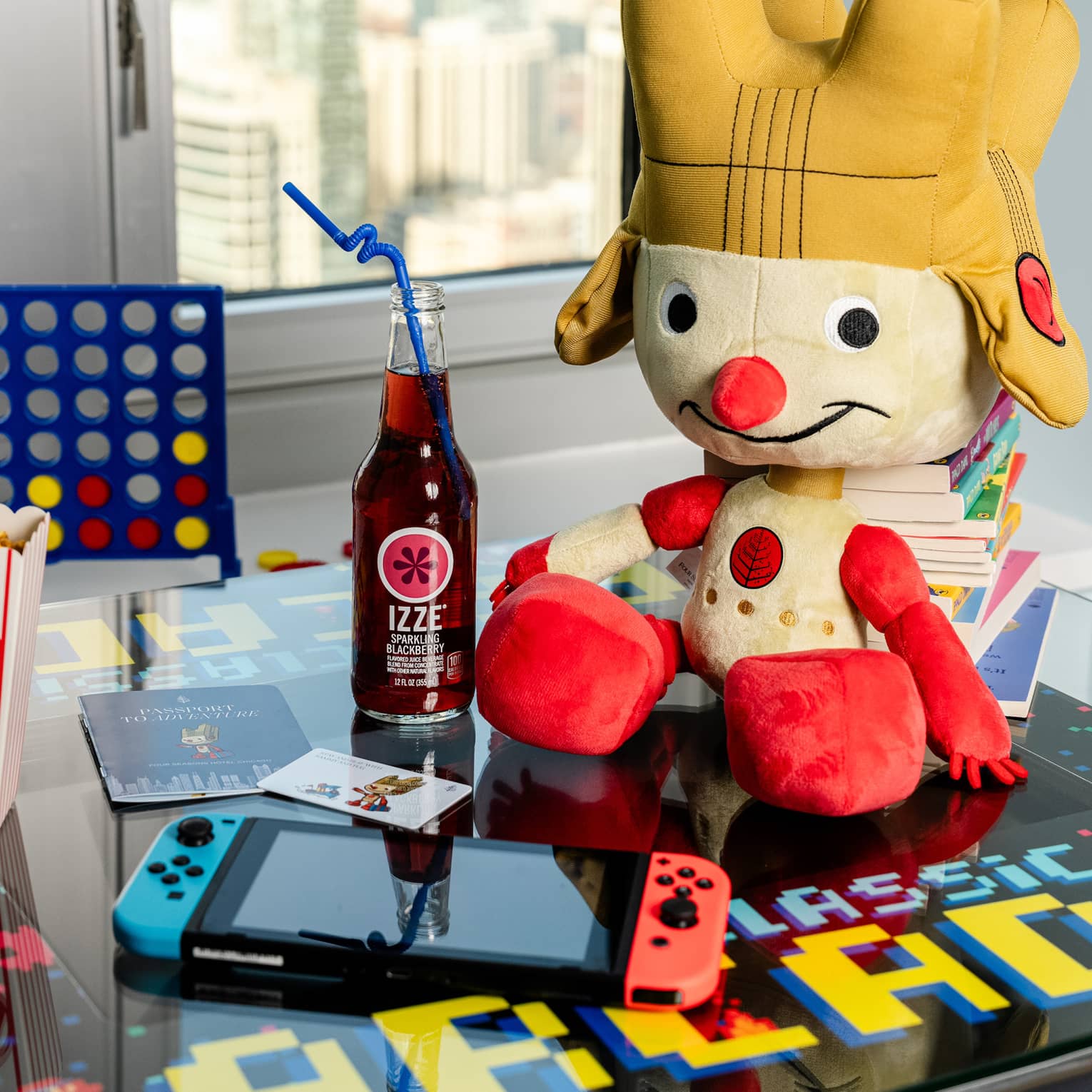 A stuffed animal, games, an electronic and popcorn on a table.