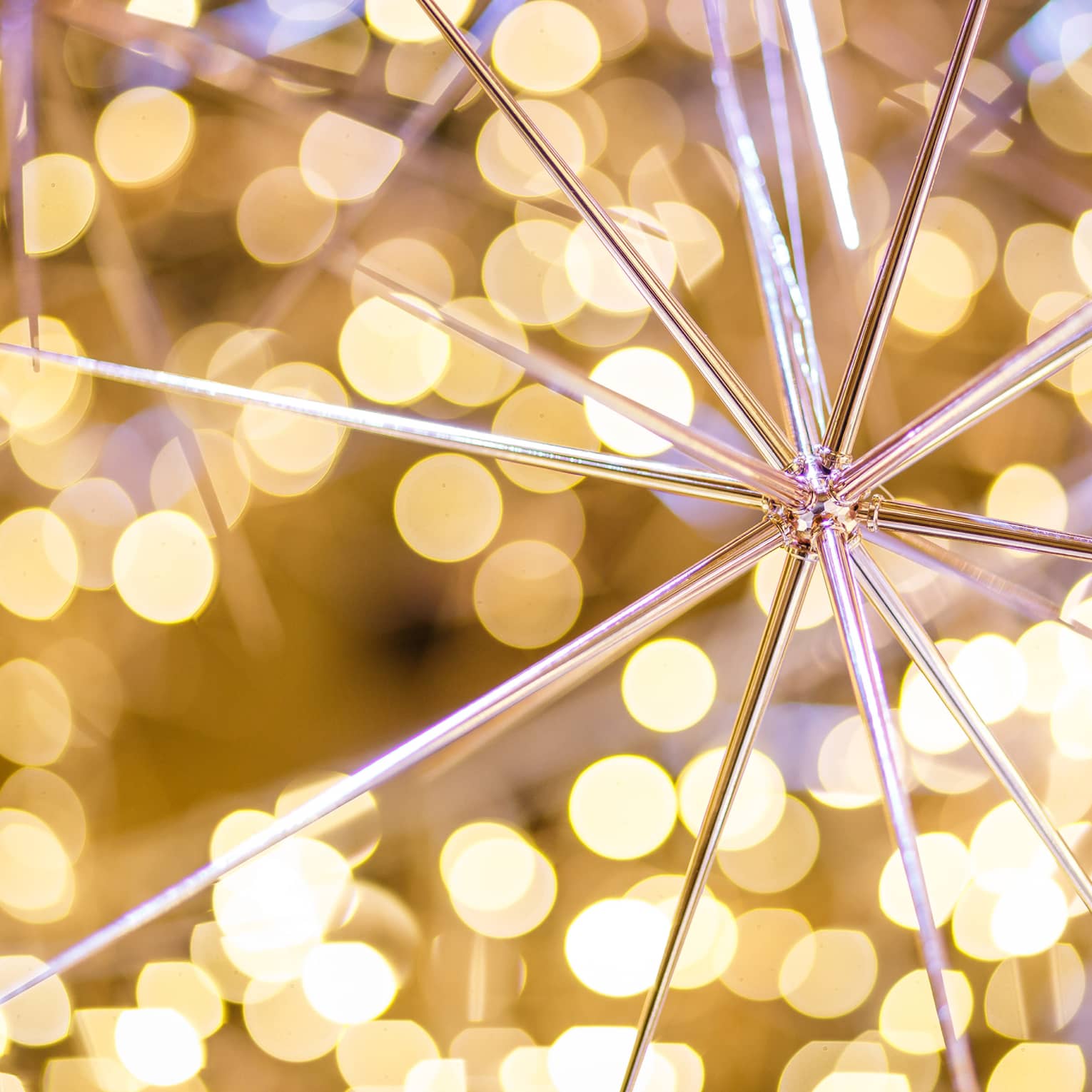 A pointy gold ornament surrounded by small yellow lights.