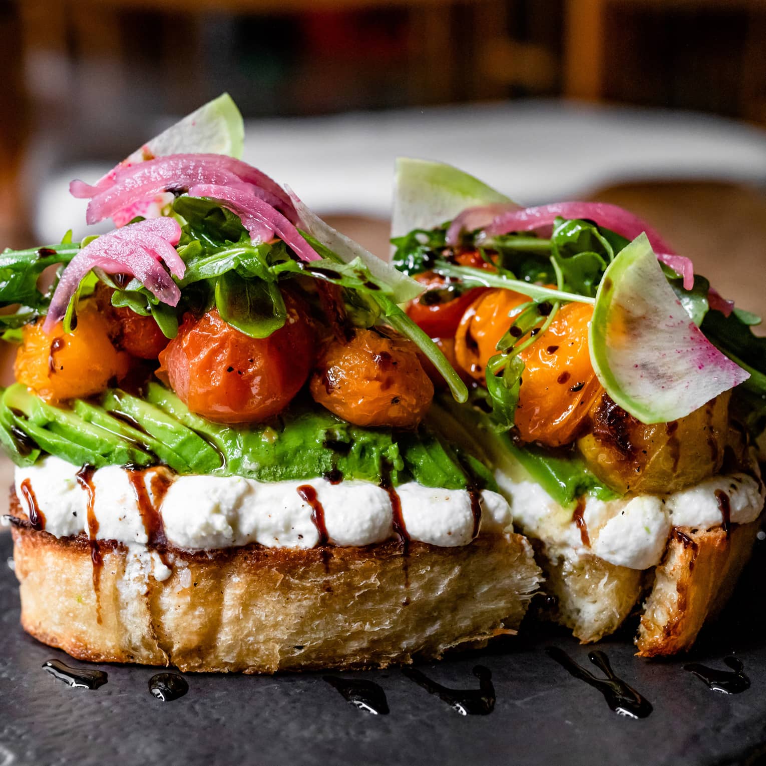Sandwich with avocado, lettuce, tomatoes and onions on top