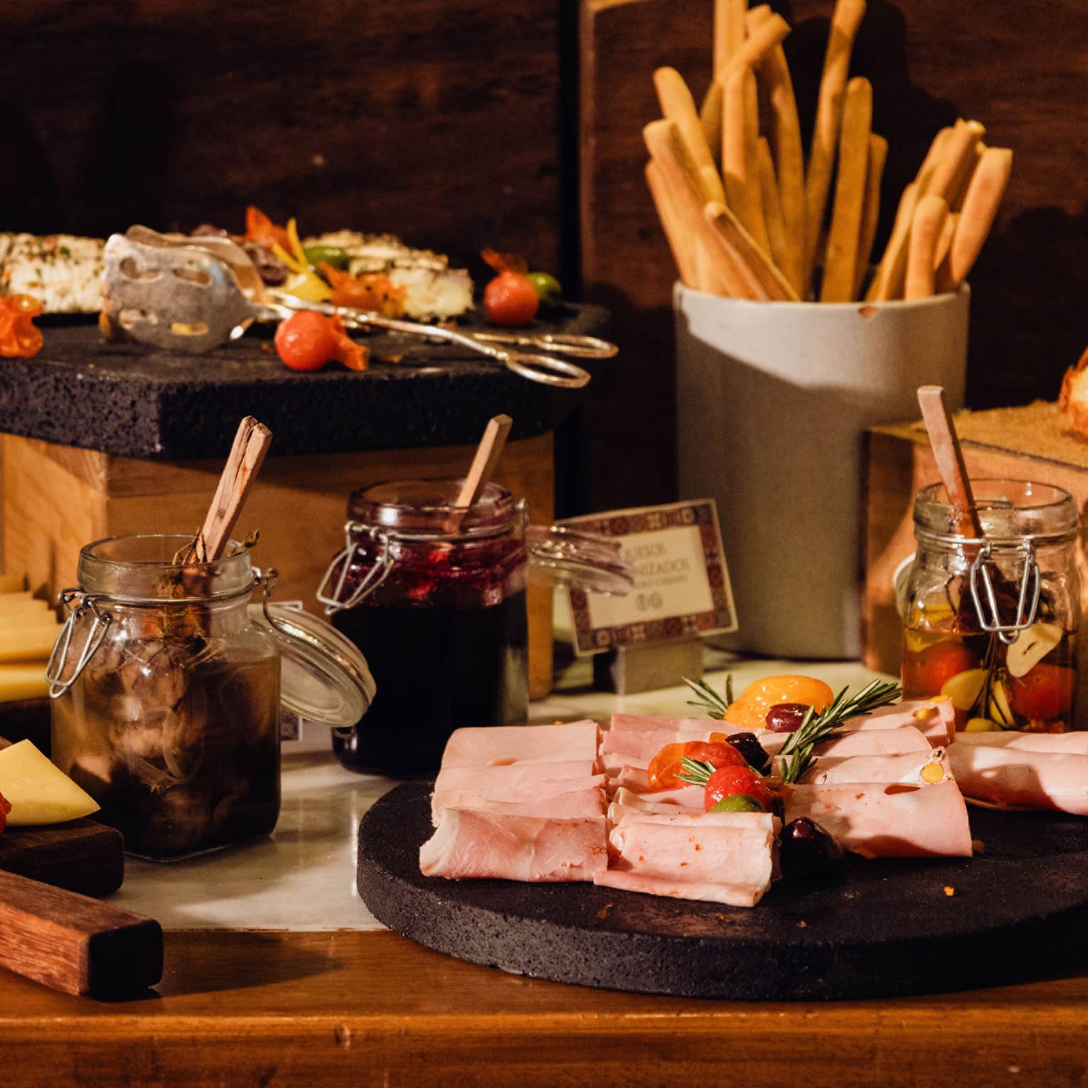 A display of sliced cheeses, meats and bread along with condiments