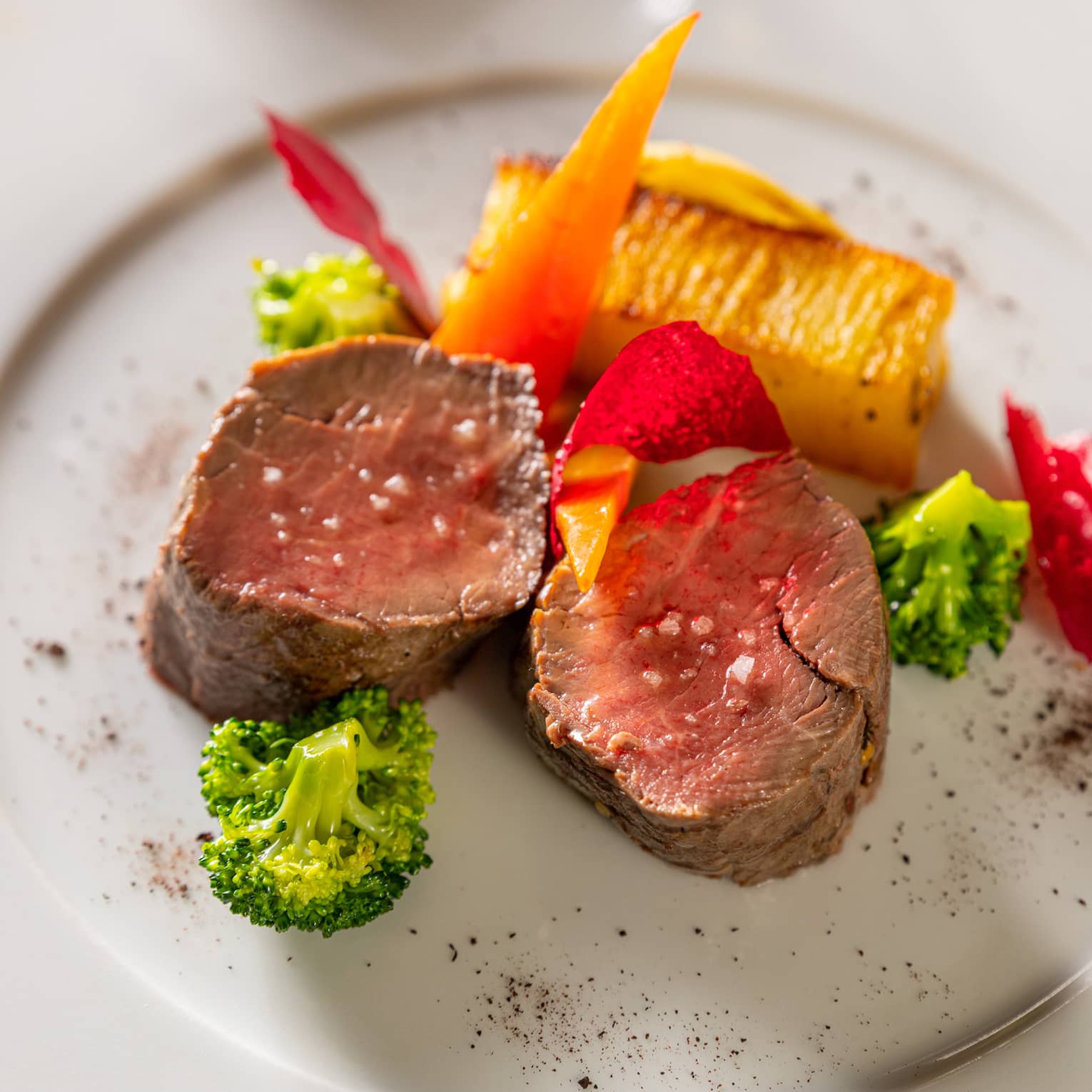 Two beef fillet medallions garnished with broccoli florets