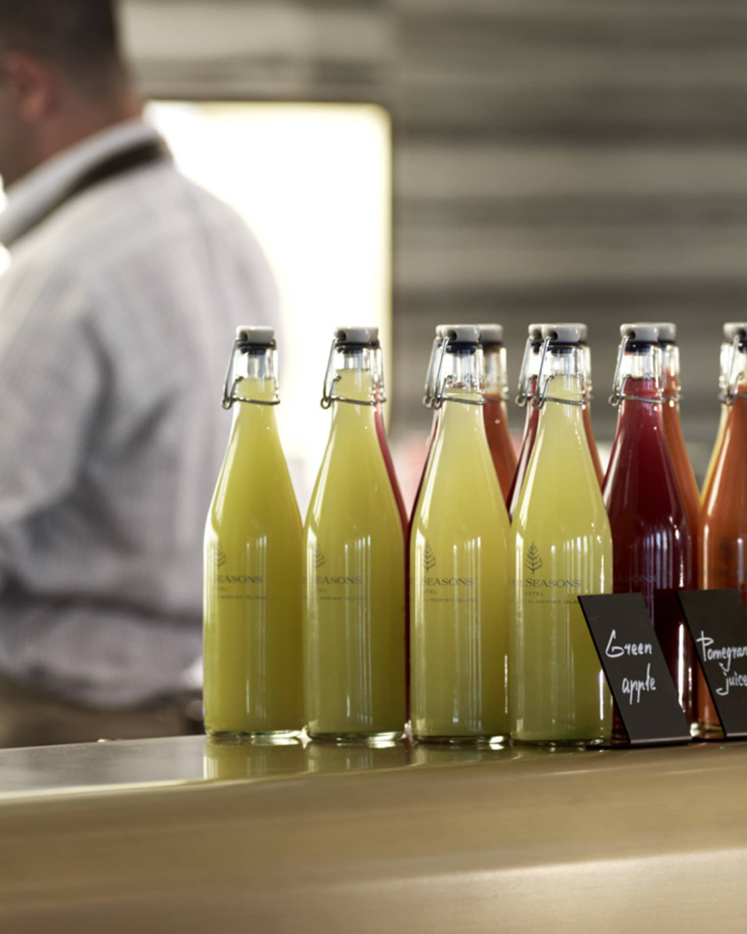 Several pressed juices sealed in glass jars on a countertop. 