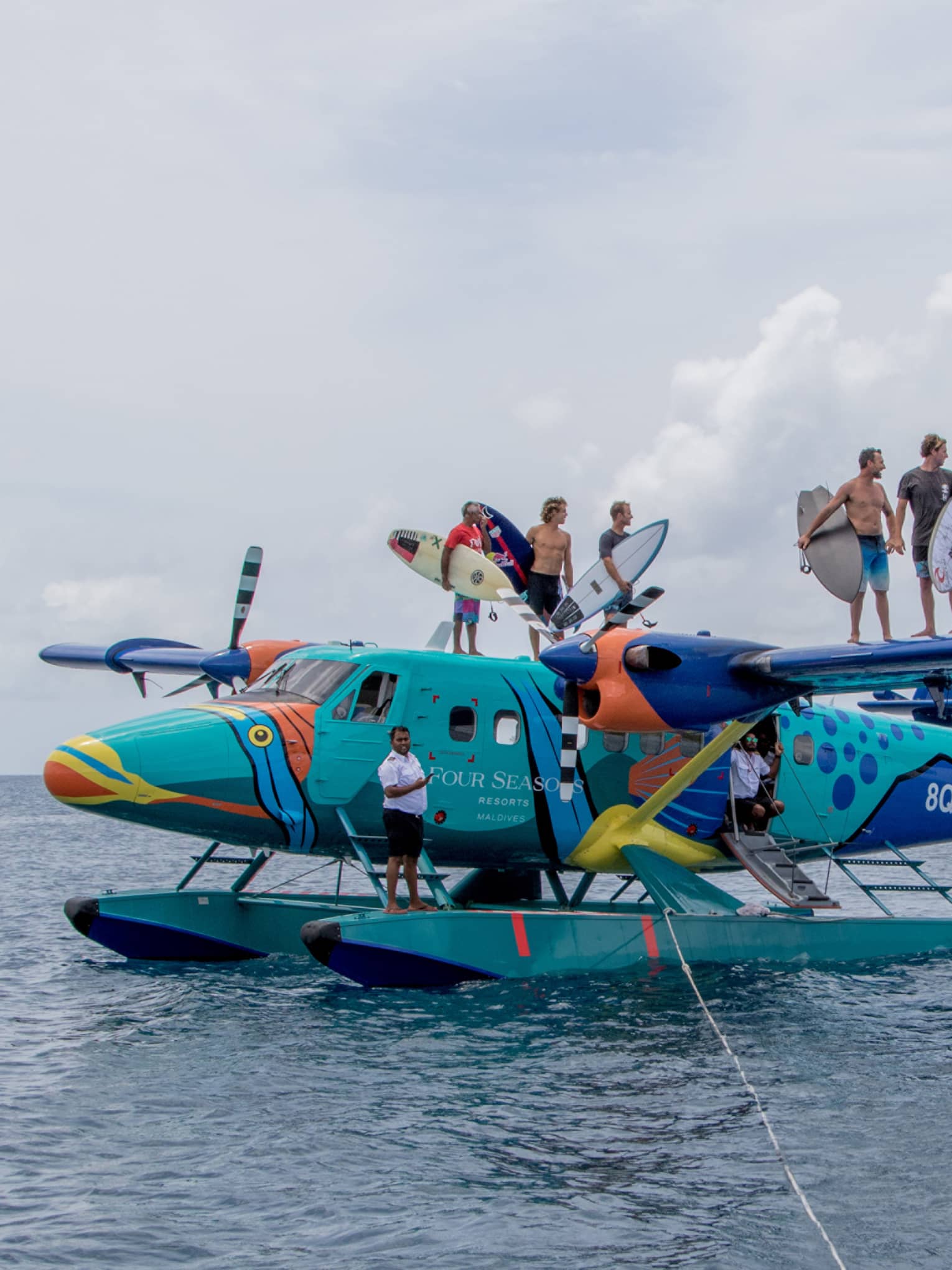 Surfers pose for camera aboard the colourful sea plane the Flying Triggerfish
