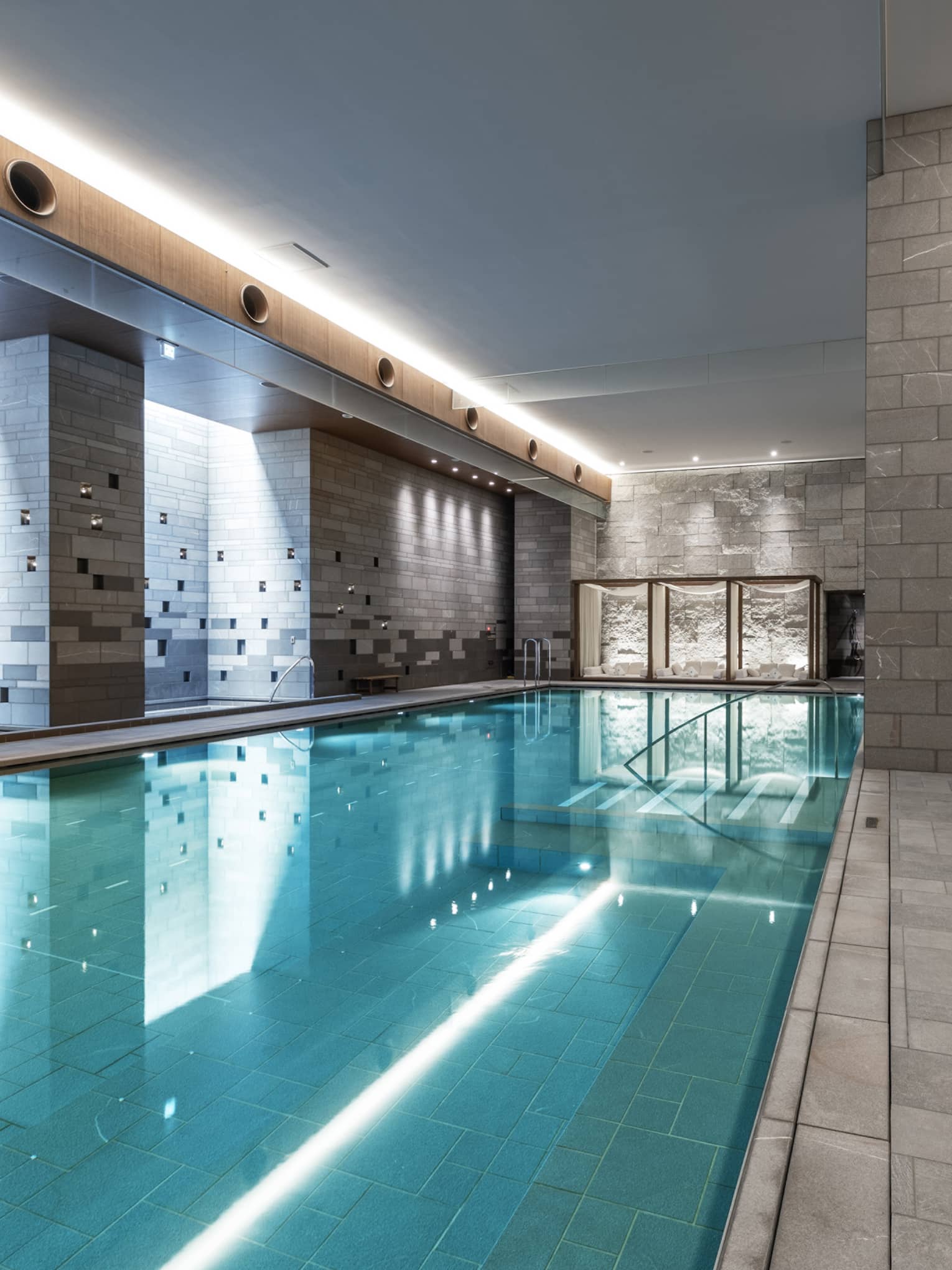 Indoor spa pool with chaise longues and grey columns