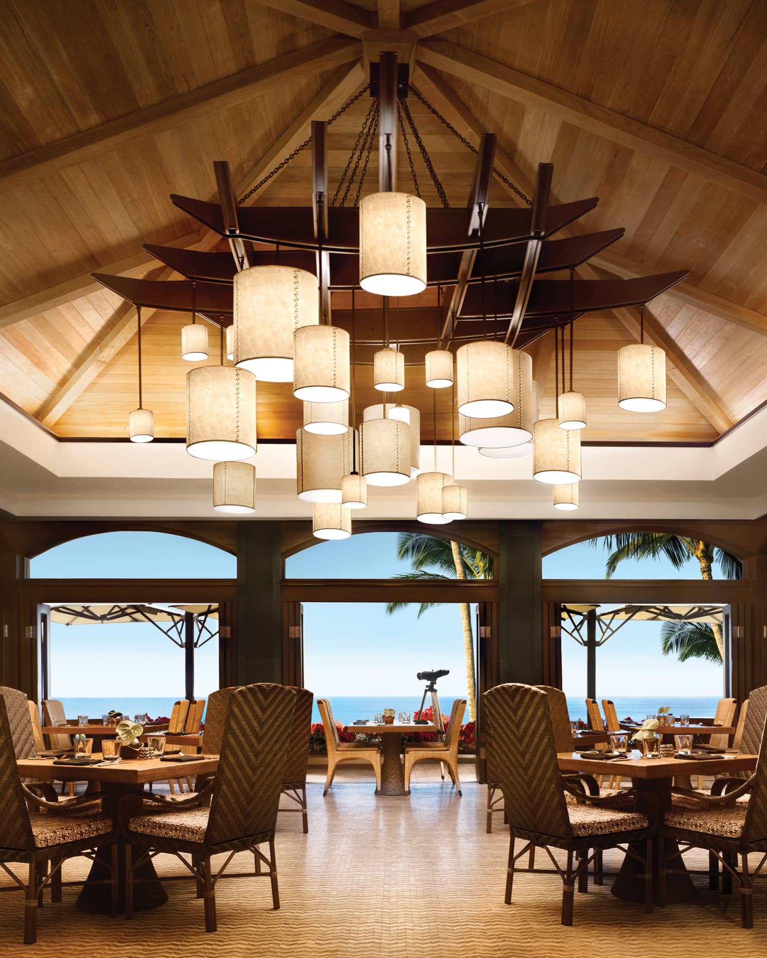 Views Restaurant dining room, tables and chairs under vaulted ceilings with modern lanterns