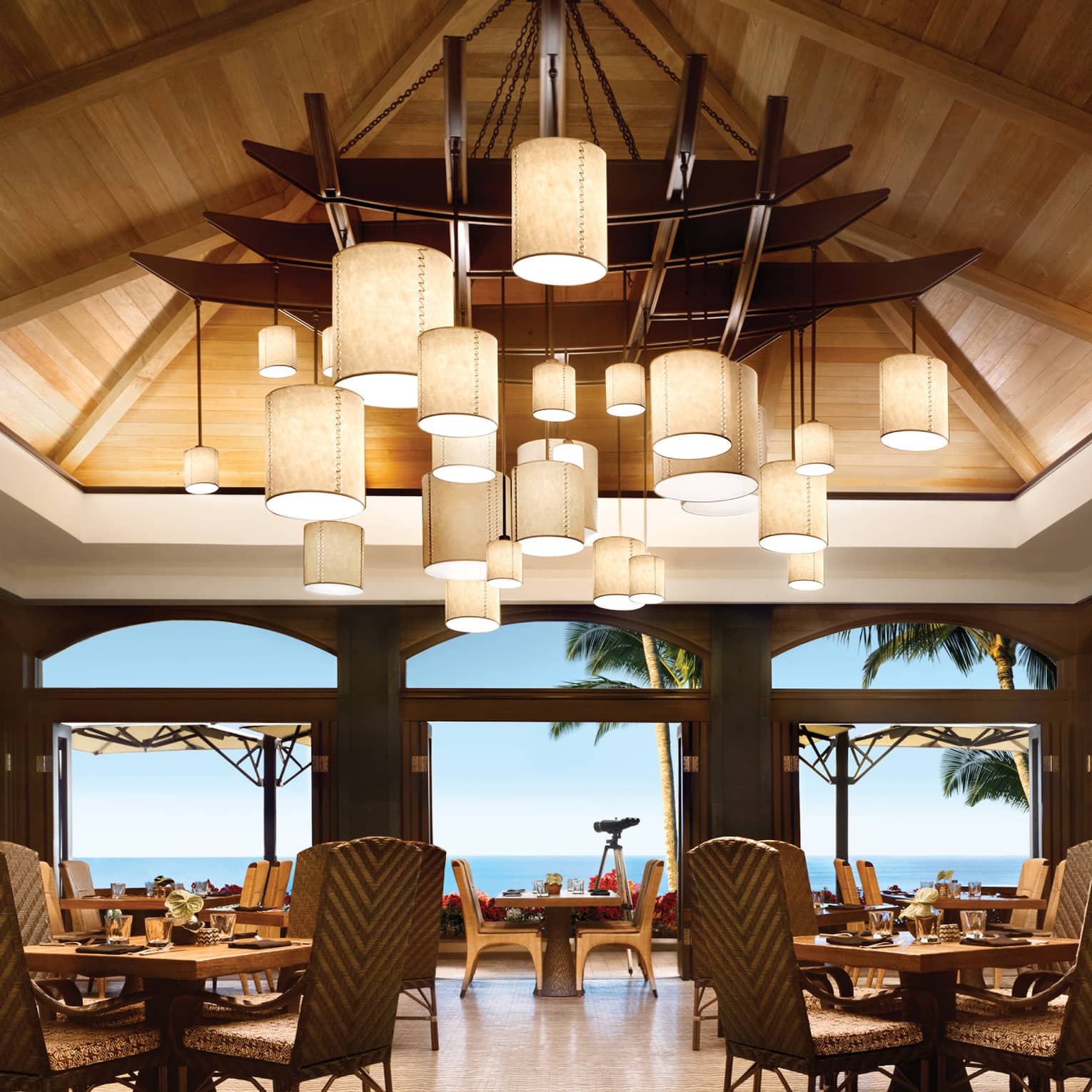 Views Restaurant dining room, tables and chairs under vaulted ceilings with modern lanterns