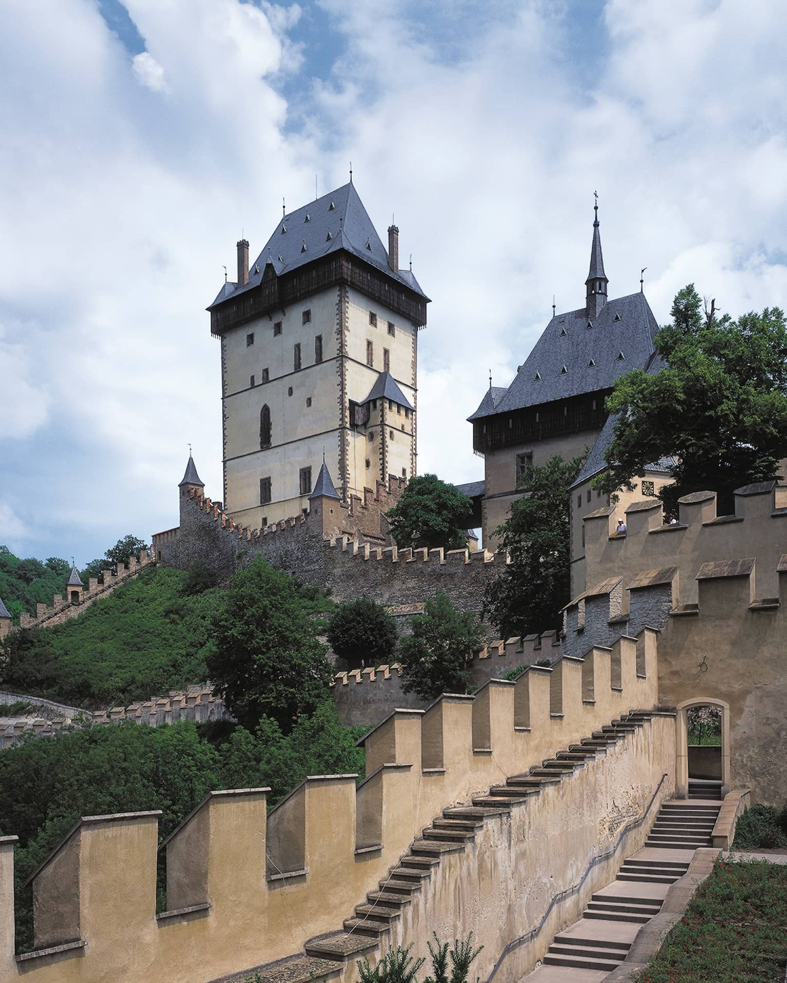 Looking up at historic Prague Karlstejn Castle towers, castle walls on sunny day