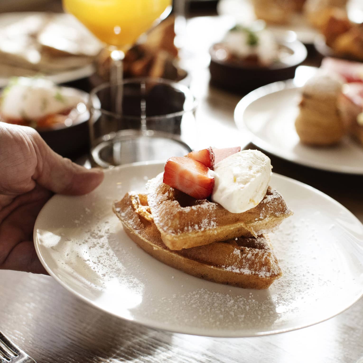 Waffles with strawberries and whipped cream on top.