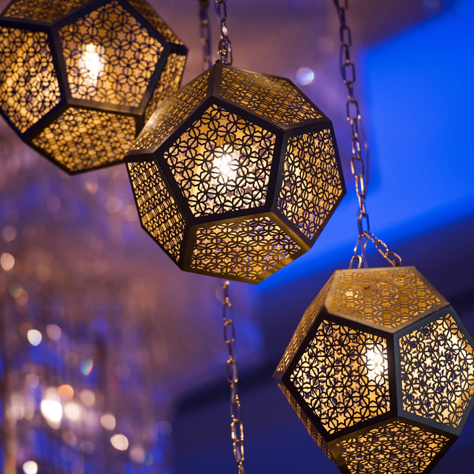 Several golden octagonal lights hanging from the ceiling, with a blue illuminated background.