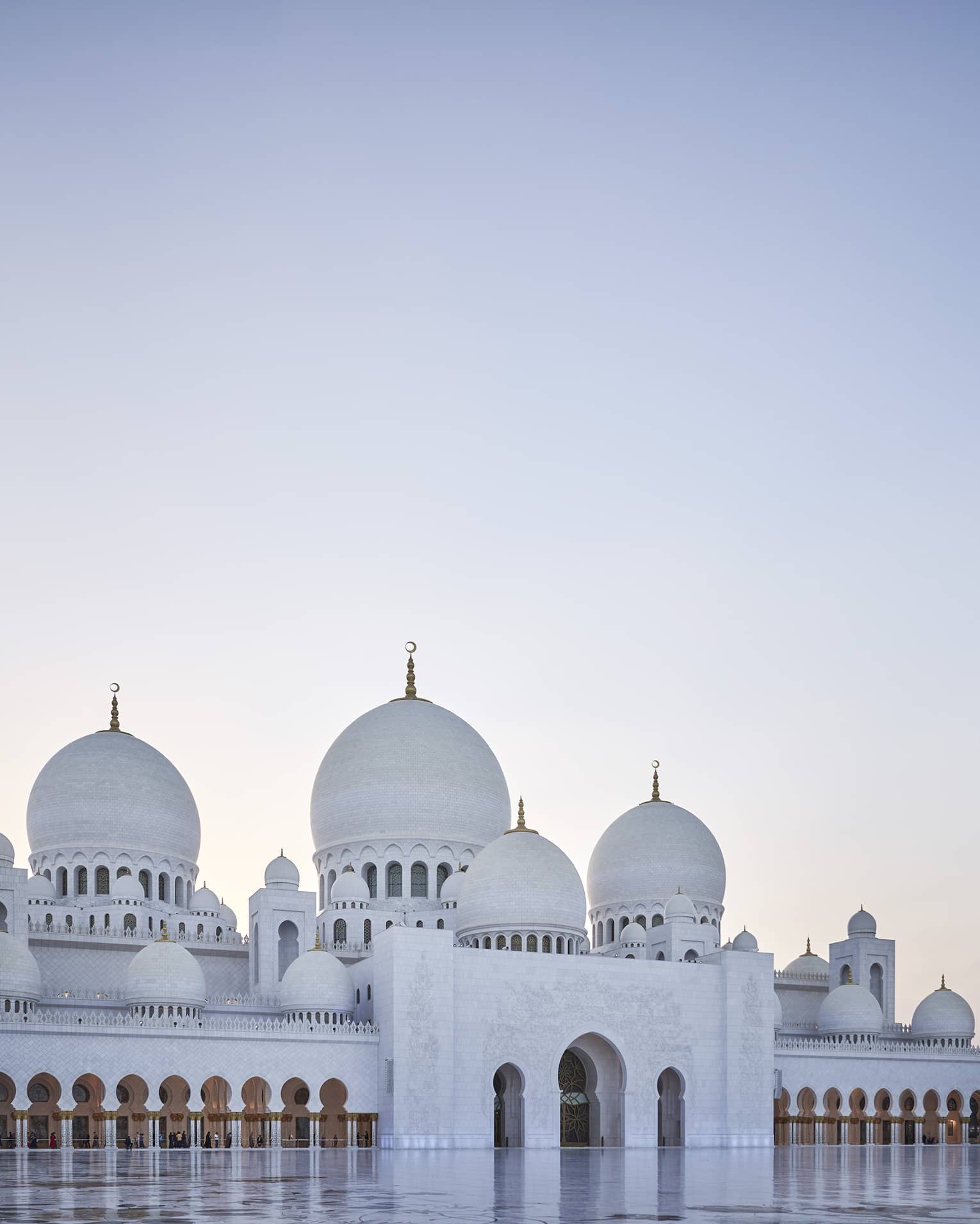 A large white mosque with two pillars made of marble.
