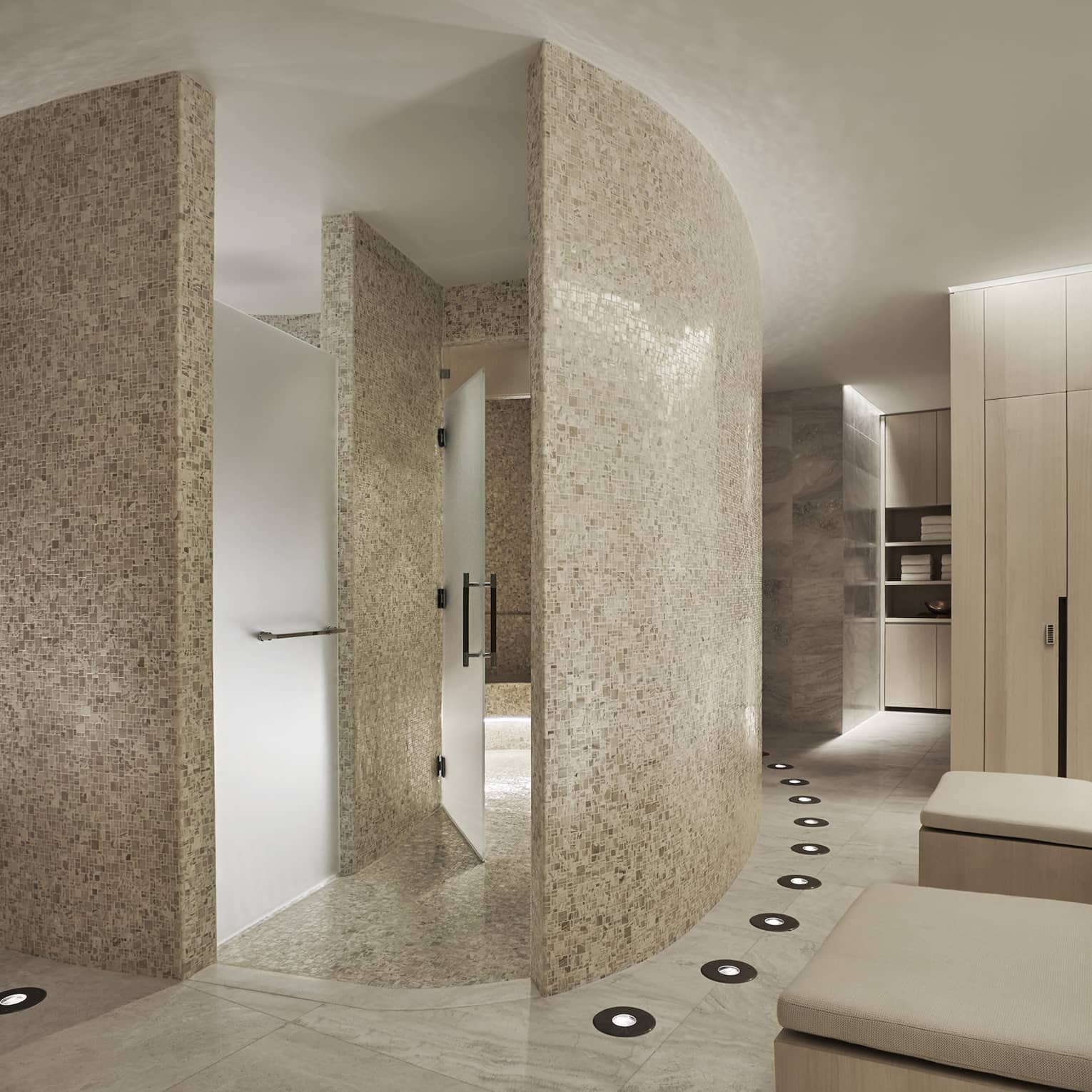 Curved white stone walls in Spa locker room, wood lockers