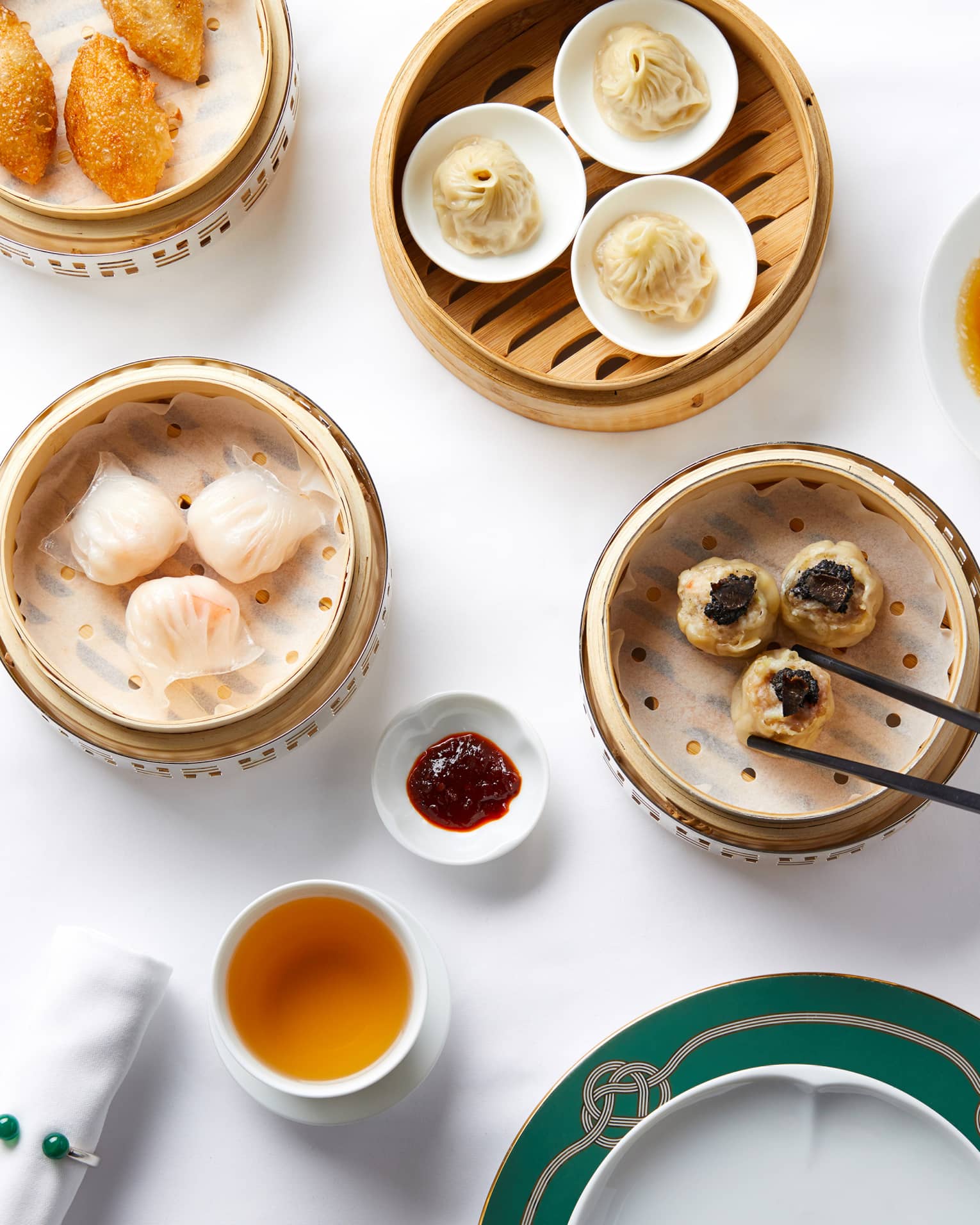 Aerial shot of Dim Sum selection, man reaching for dumplings steamer basket with chopsticks