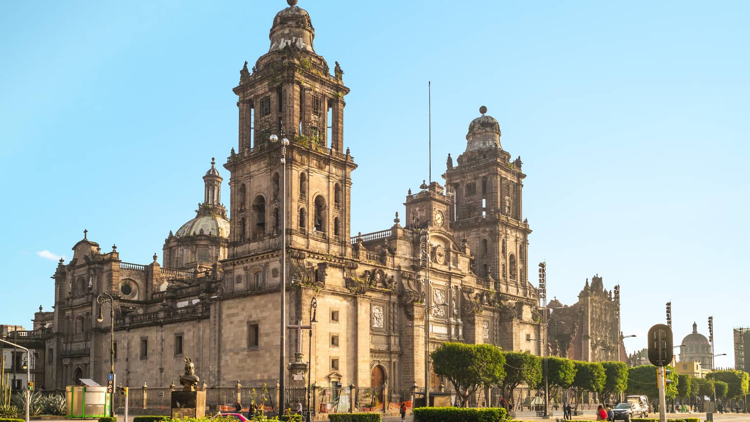 A large old building surrounded by streets and plants.
