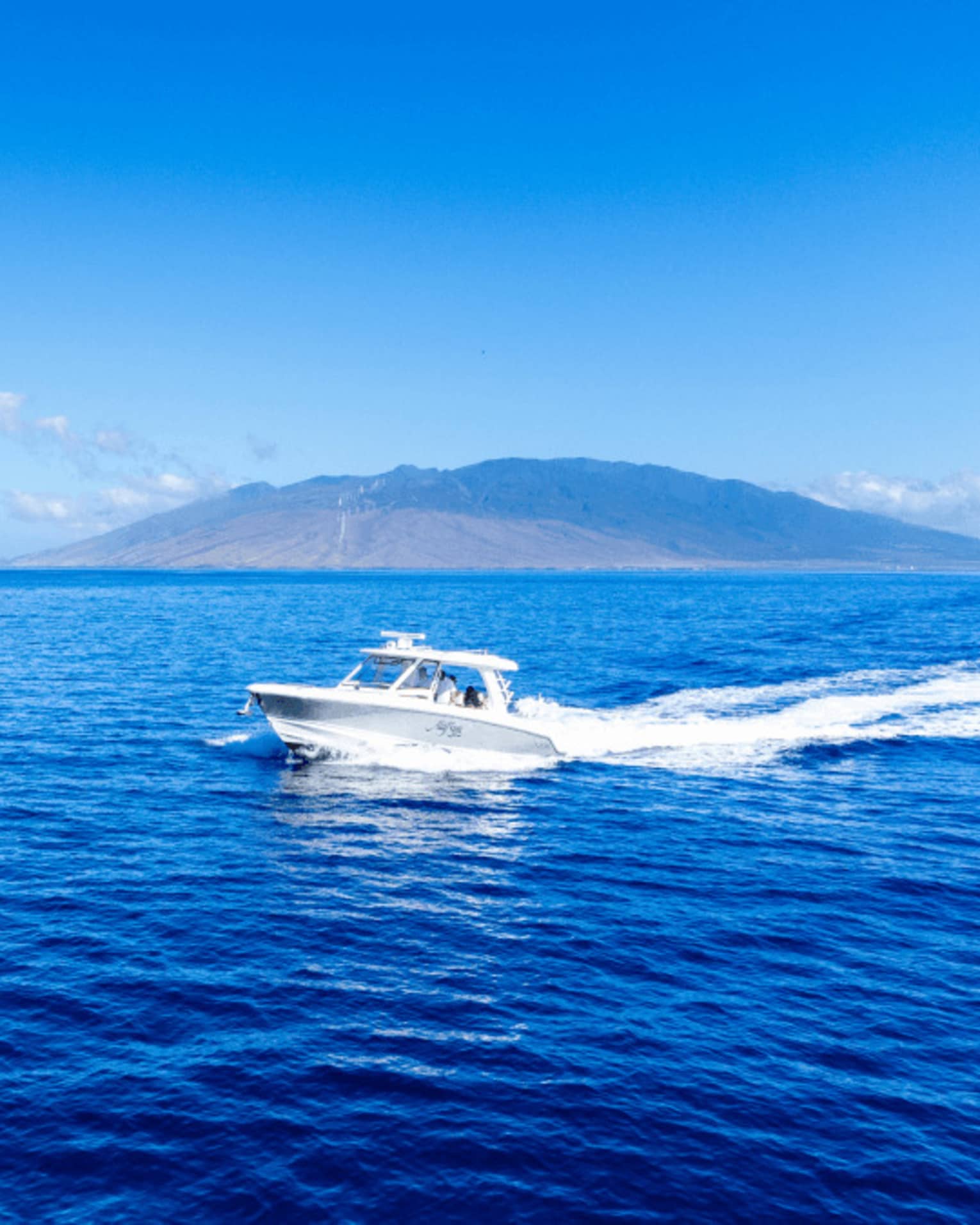 A boat on the water with island in the background