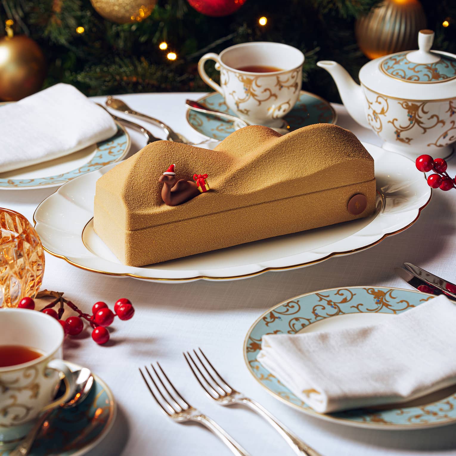 B�che de No�l designed to look like a dessert sand dune with a decorative camel wearing a red Santa hat